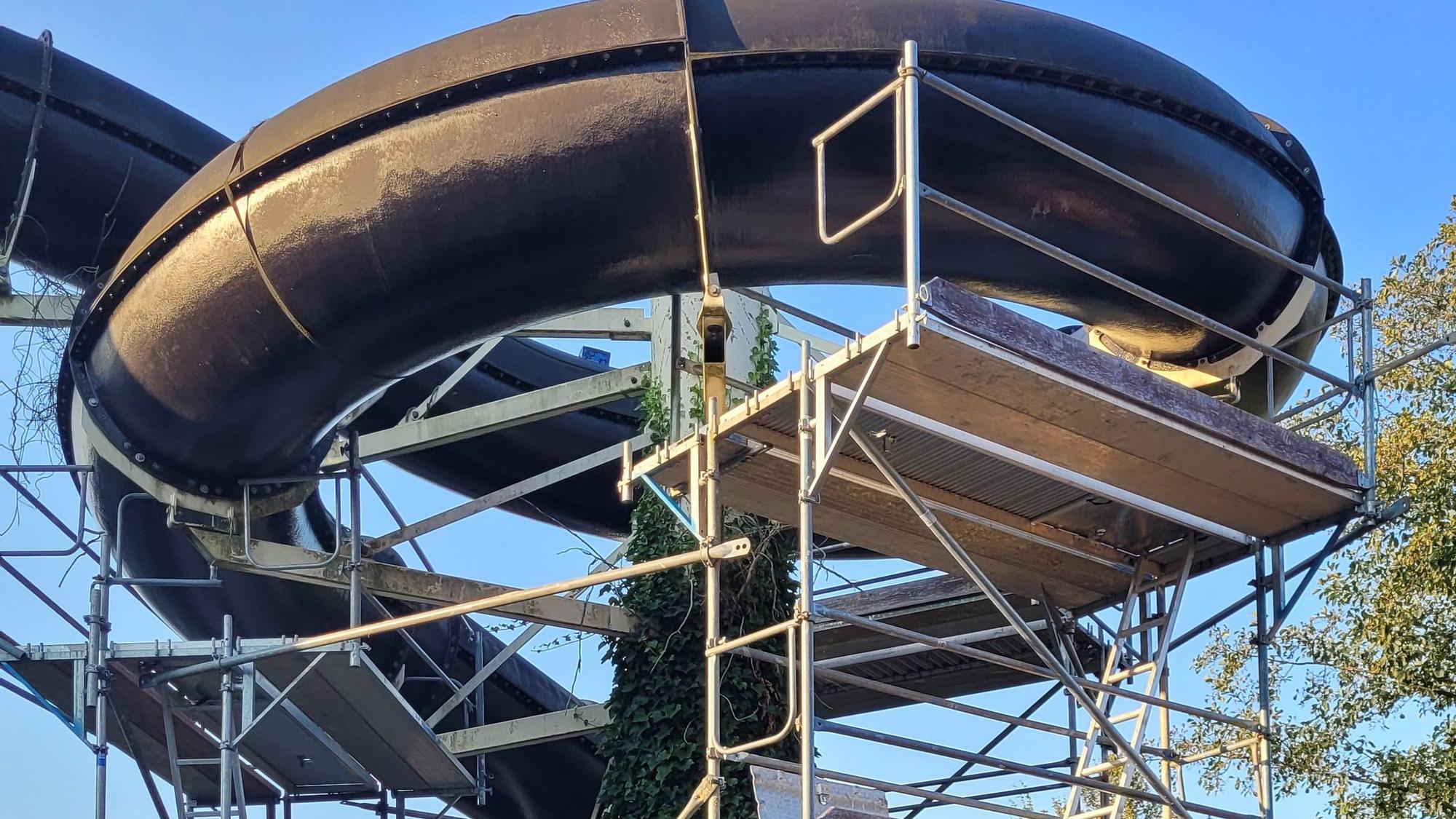 Eine Wasserrutsche mit einem Baustellengerüst darum ist zu sehen.