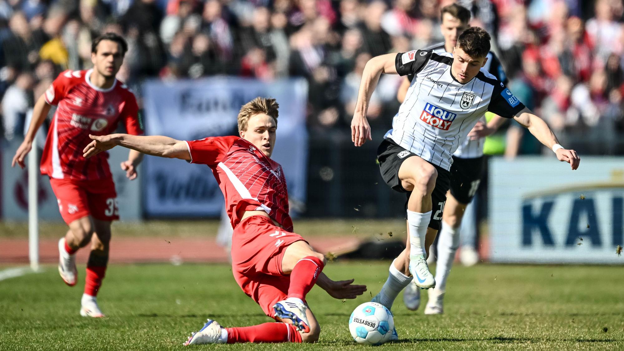 Kölns Timo Hübers (l) in Aktion gegen Ulms Semir Telalovic (r).