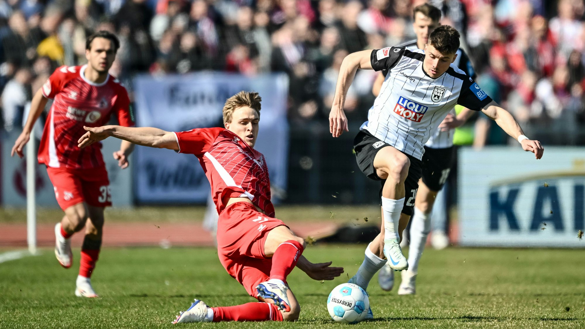 Kölns Timo Hübers (l) in Aktion gegen Ulms Semir Telalovic (r).