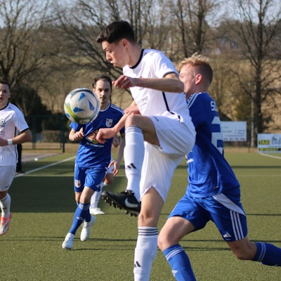 Nierfeld Yannick Lenhard nimmt einen Ball akrobatisch an, während ein Gegenspieler ihn bedrängt.