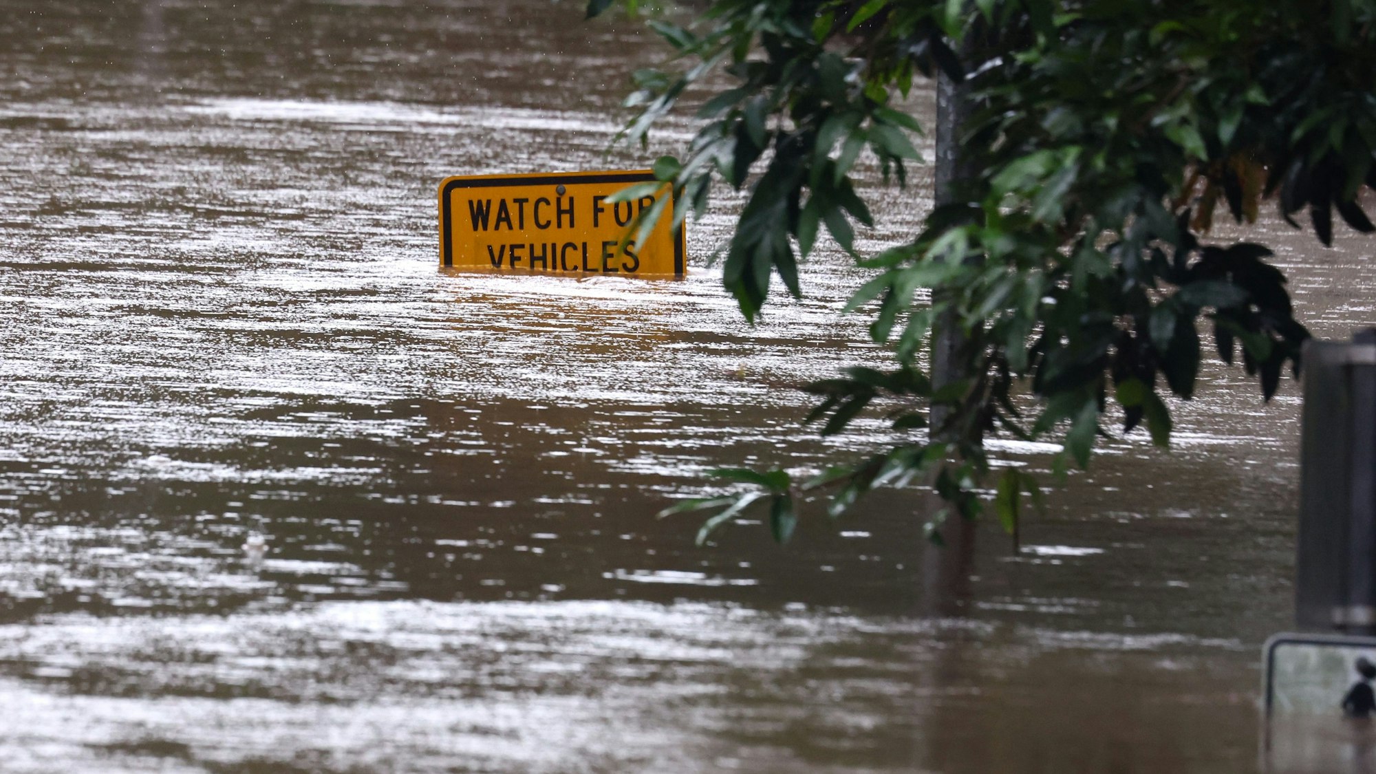 Die Straße ist überflutet. Der als Zyklon auf Australiens Ostküste zugesteuerte Sturm „Alfred“ hat an Stärke verloren und ist zu einem tropischen Tiefdruckgebiet herabgestuft worden.