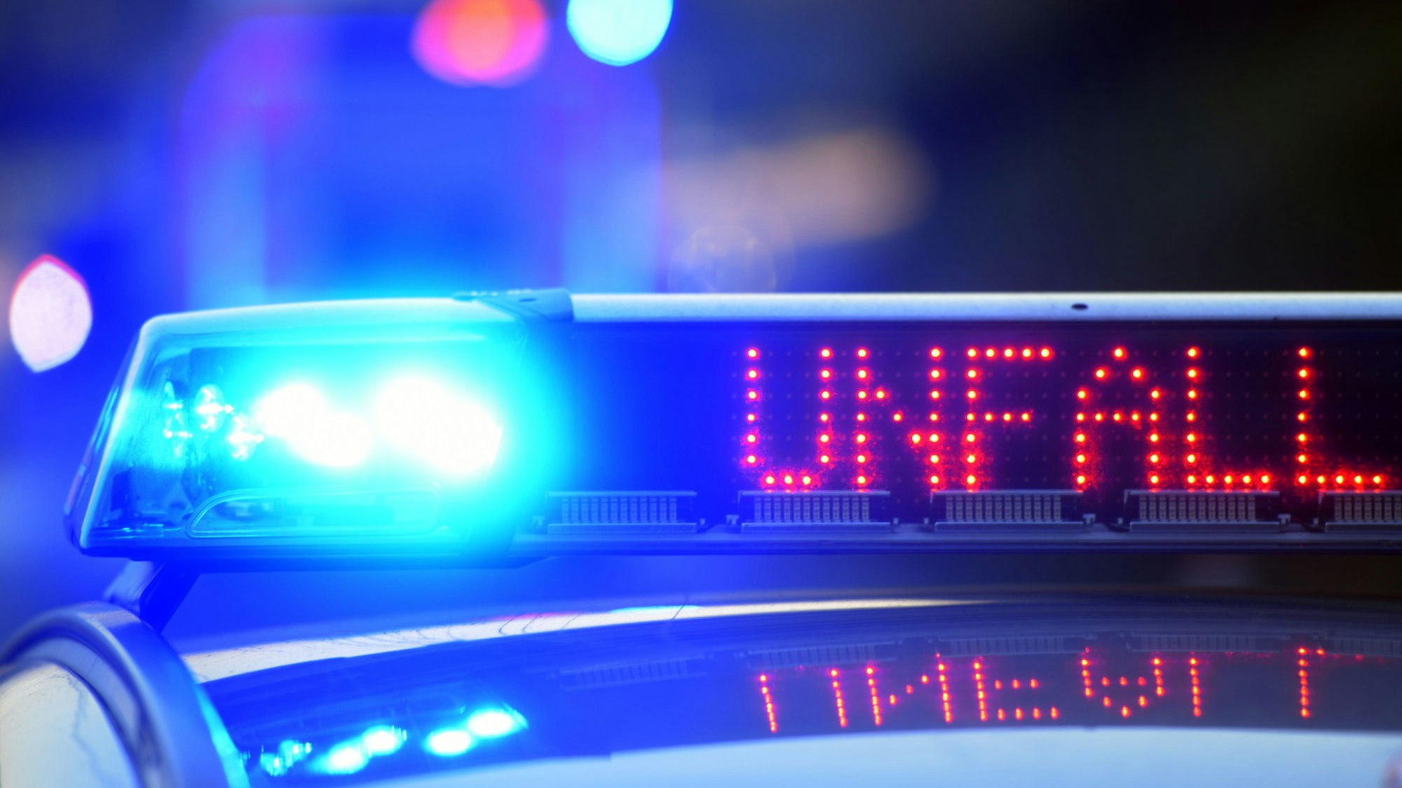 Auf einem Polizeifahrzeug warnt eine Leuchtschrift vor einer Unfallstelle.