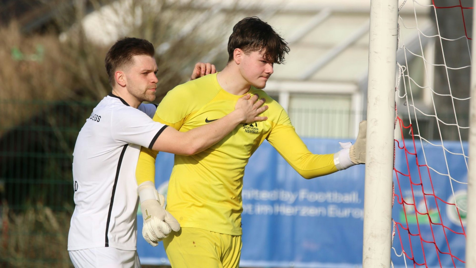 Ein Mitspieler umarmt Paul Frings, der sichtlich frustriert ist.