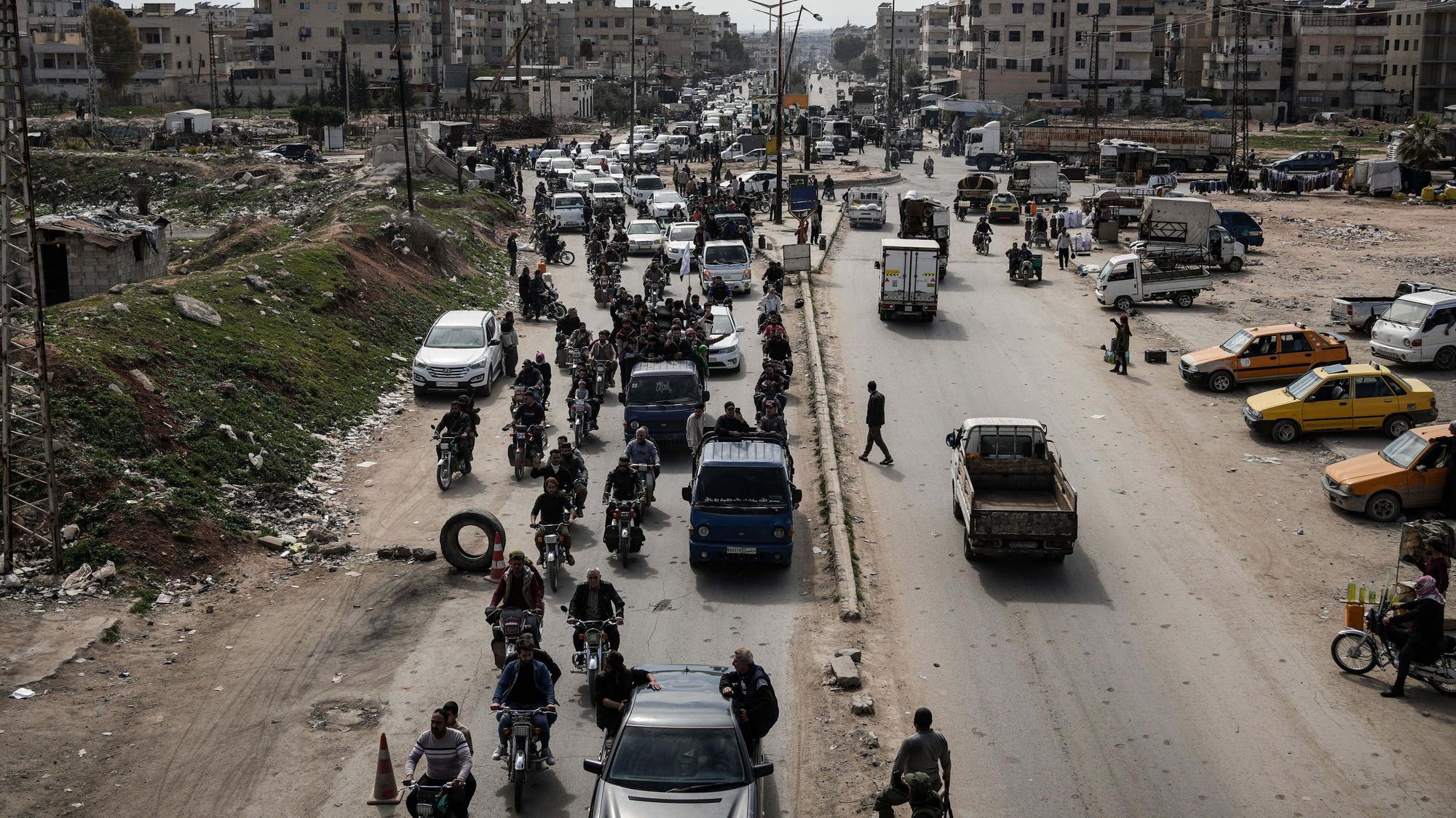Syrische Kämpfer und Zivilisten nehmen an der Beerdigung eines Mitglieds der syrischen Sicherheitskräfte in der Provinz Hama teil.
