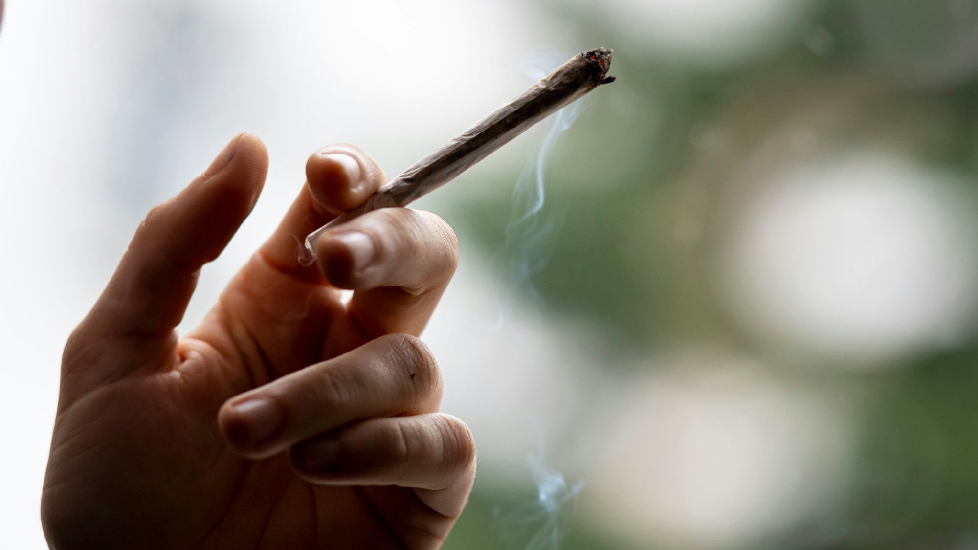 Eine Person raucht einen Joint. Mehrheit der Deutschen gegen eine Abschaffung des Cannabisgesetzes