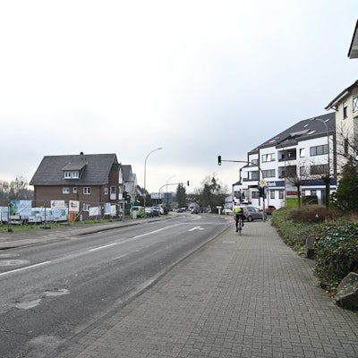 Eine Straße, links ein freies Baugelände.