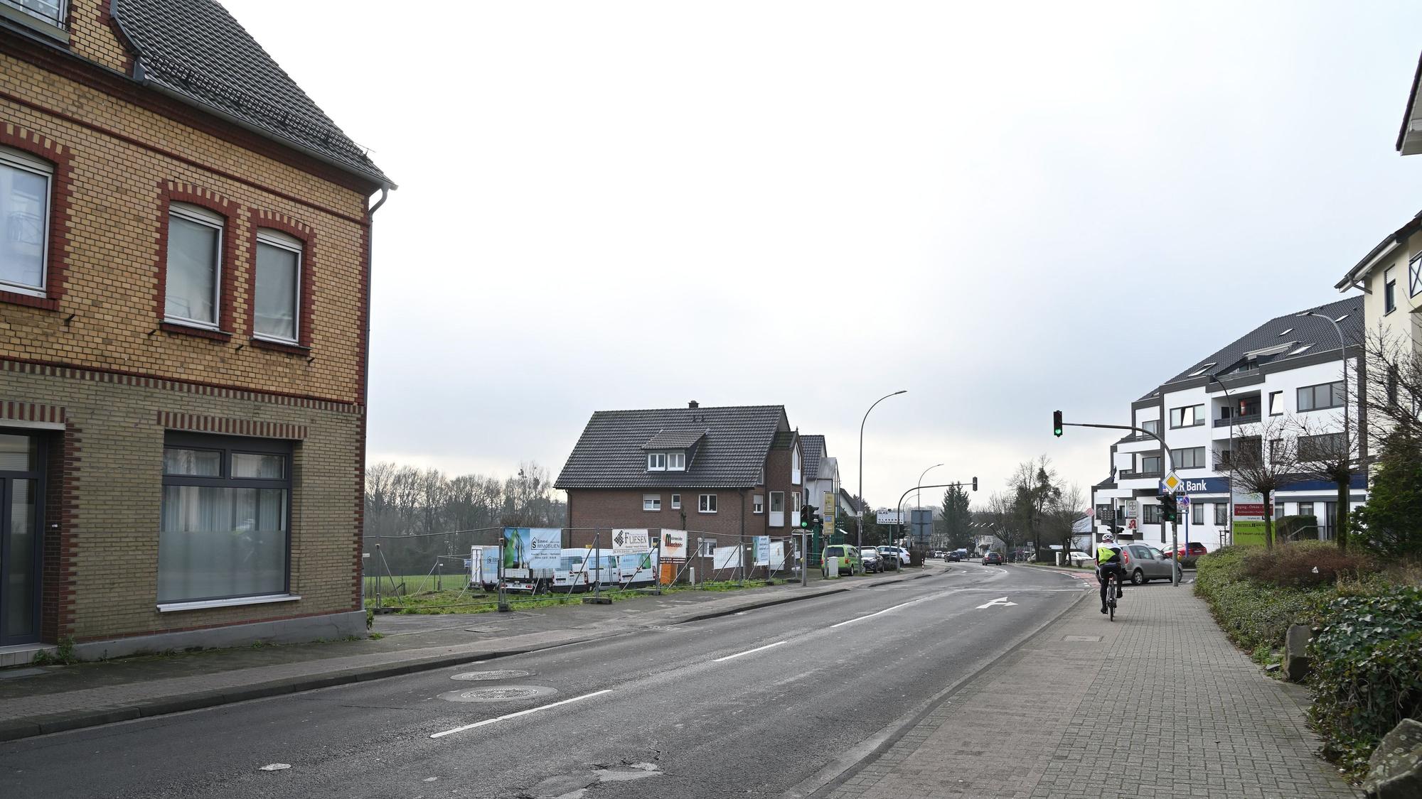 Eine Straße, links ein freies Baugelände.