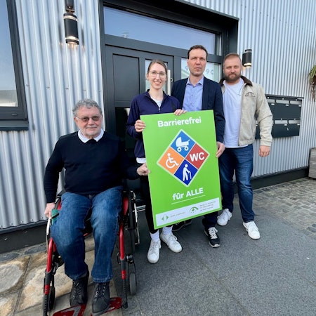 Vier Menschen mit Plakat