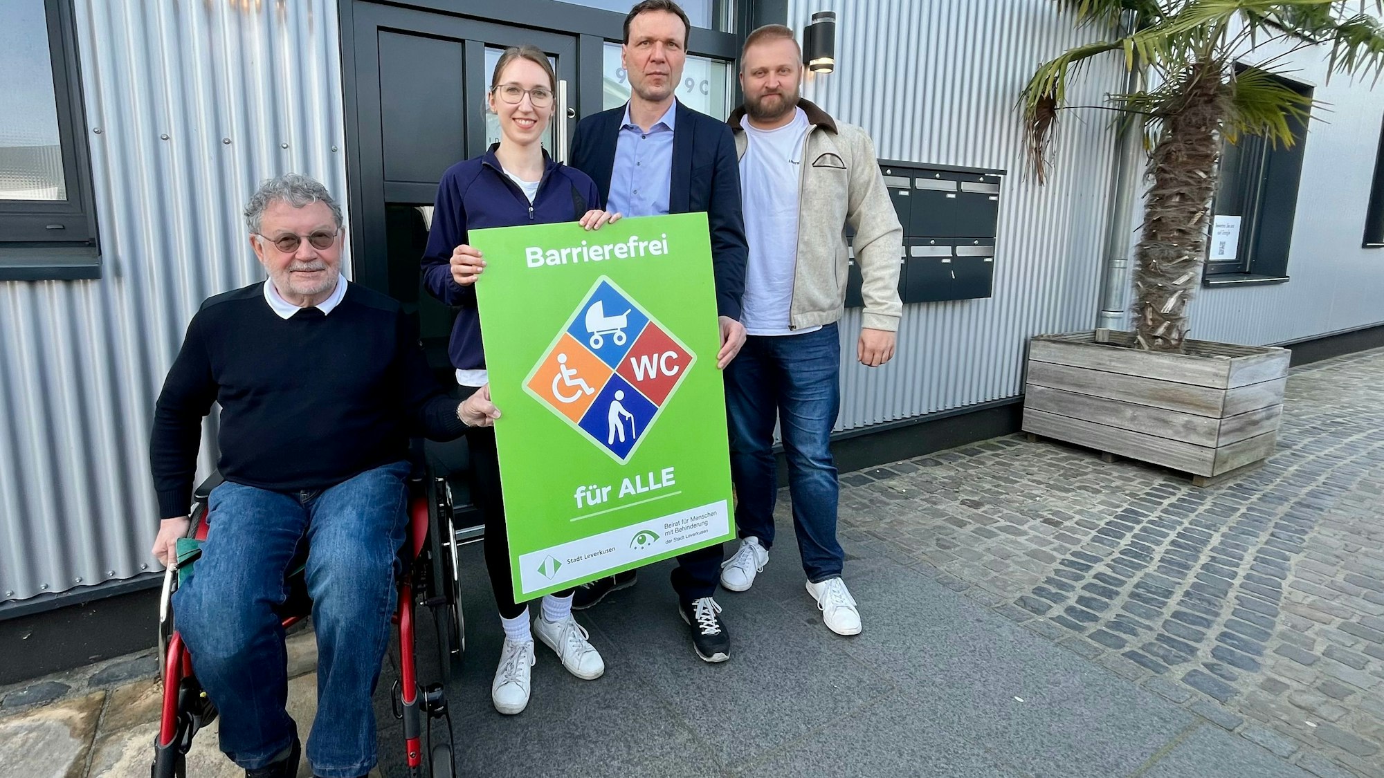 Vier Menschen mit Plakat