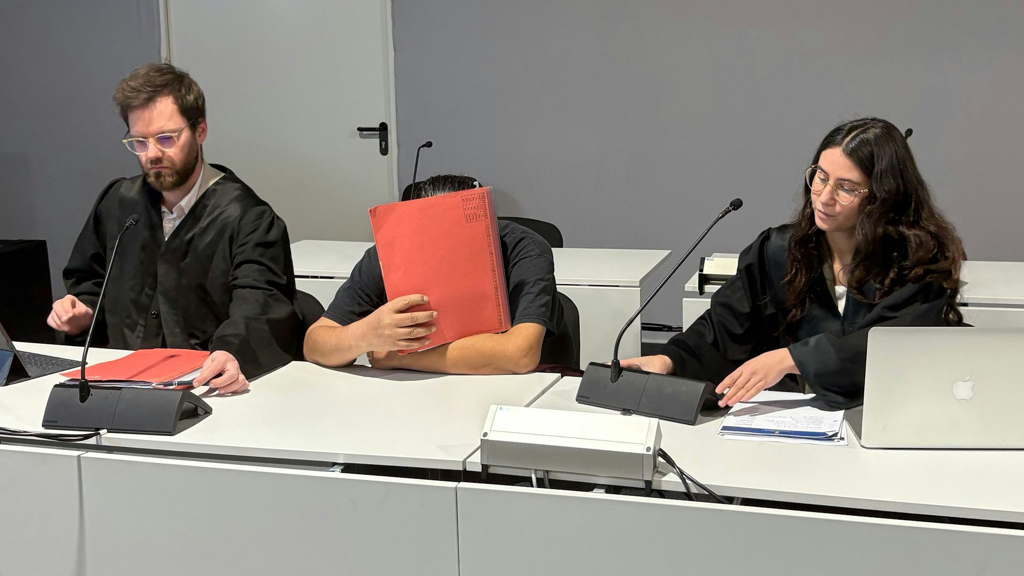 Der Angeklagte zwischen den Verteidigern Björn Huppertz und Tamara Pütz in Saal B des Kölner Landgerichts.