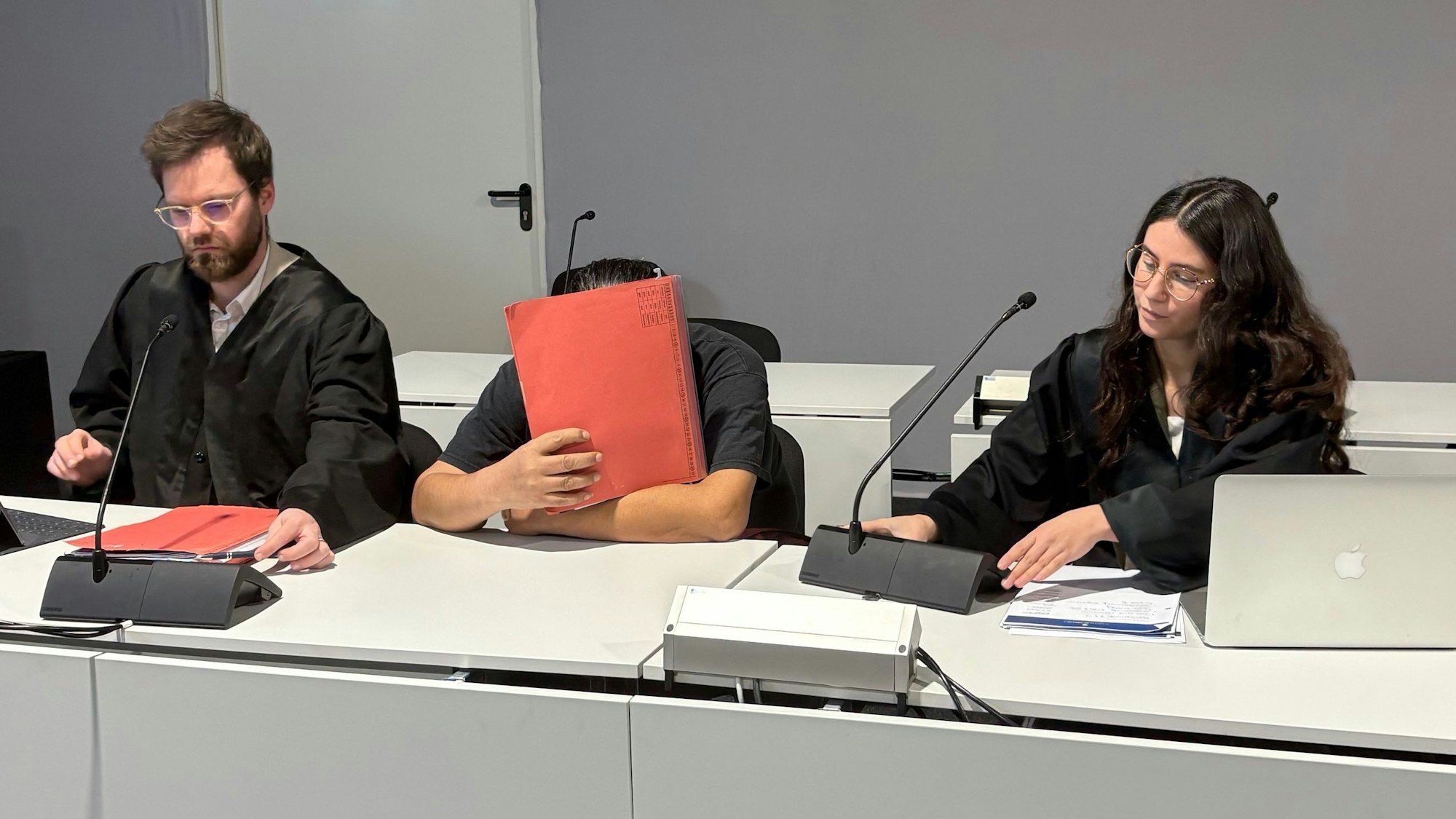 Der Angeklagte zwischen den Verteidigern Björn Huppertz und Tamara Pütz in Saal B des Kölner Landgerichts