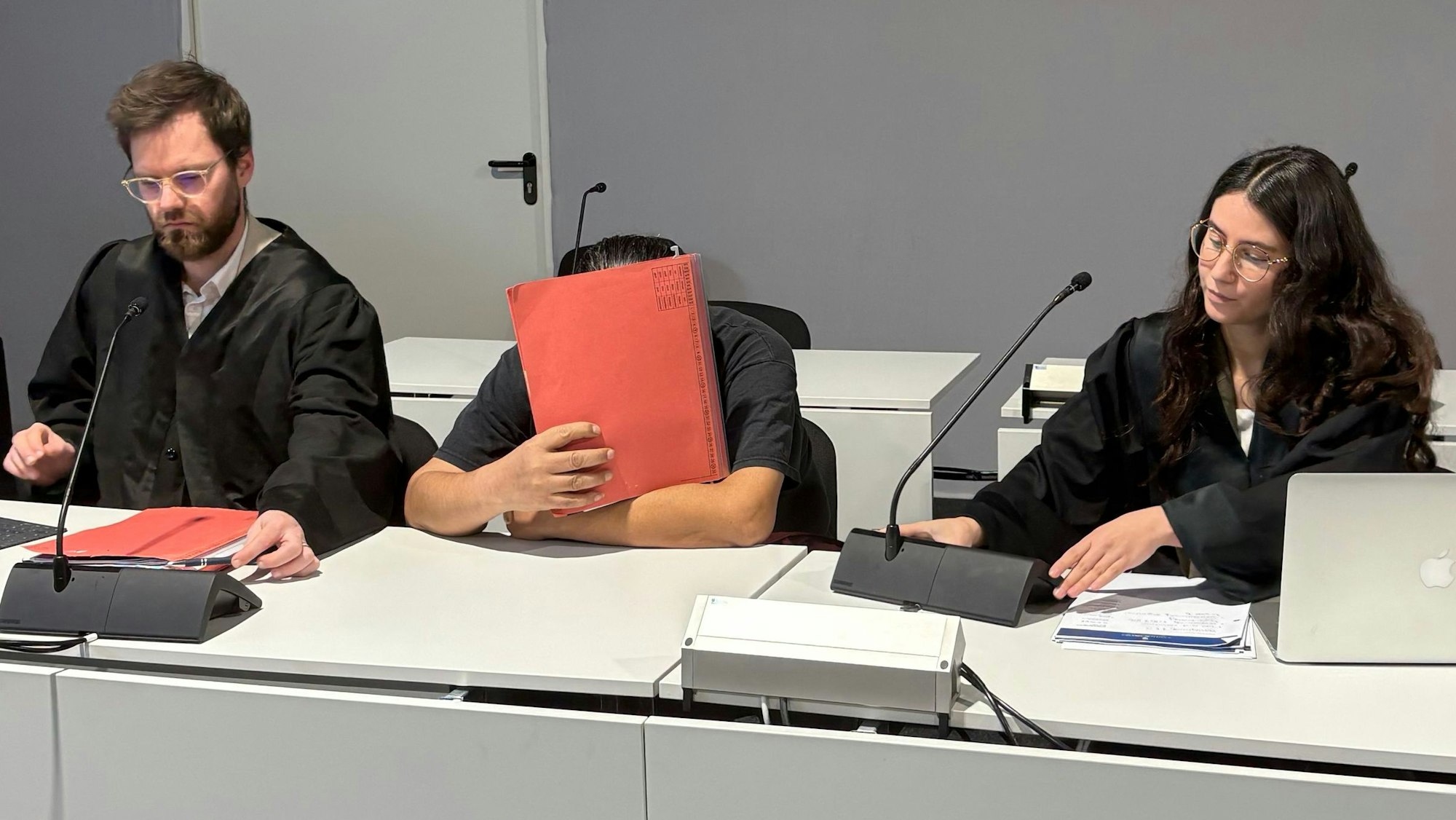 Der Angeklagte zwischen den Verteidigern Björn Huppertz und Tamara Pütz in Saal B des Kölner Landgerichts.