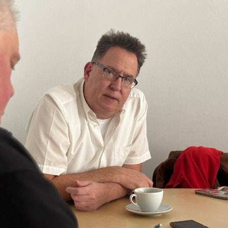 Ein Mann sitzt an einem Tisch.