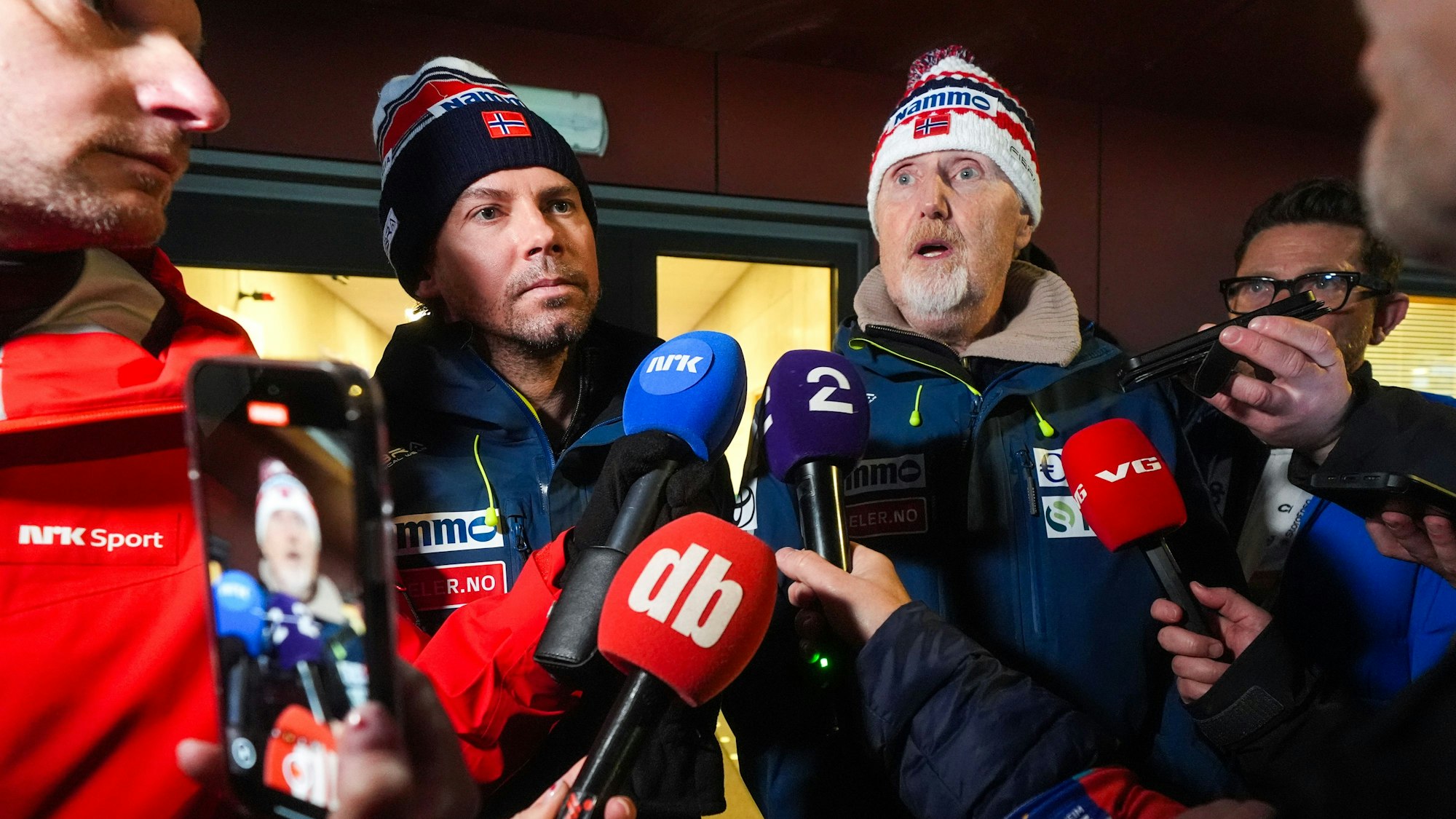 Der Trainer der Skisprung-Nationalmannschaft, Magnus Brevig (l), und der Sportdirektor Jan-Erik Aalbu beantworten in Granåsen die Fragen der Presse, nachdem zwei norwegische Springer nach dem Großschanzenspringen der Männer bei den Skiweltmeisterschaften in Trondheim disqualifiziert und des Betrugs beschuldigt wurden.
