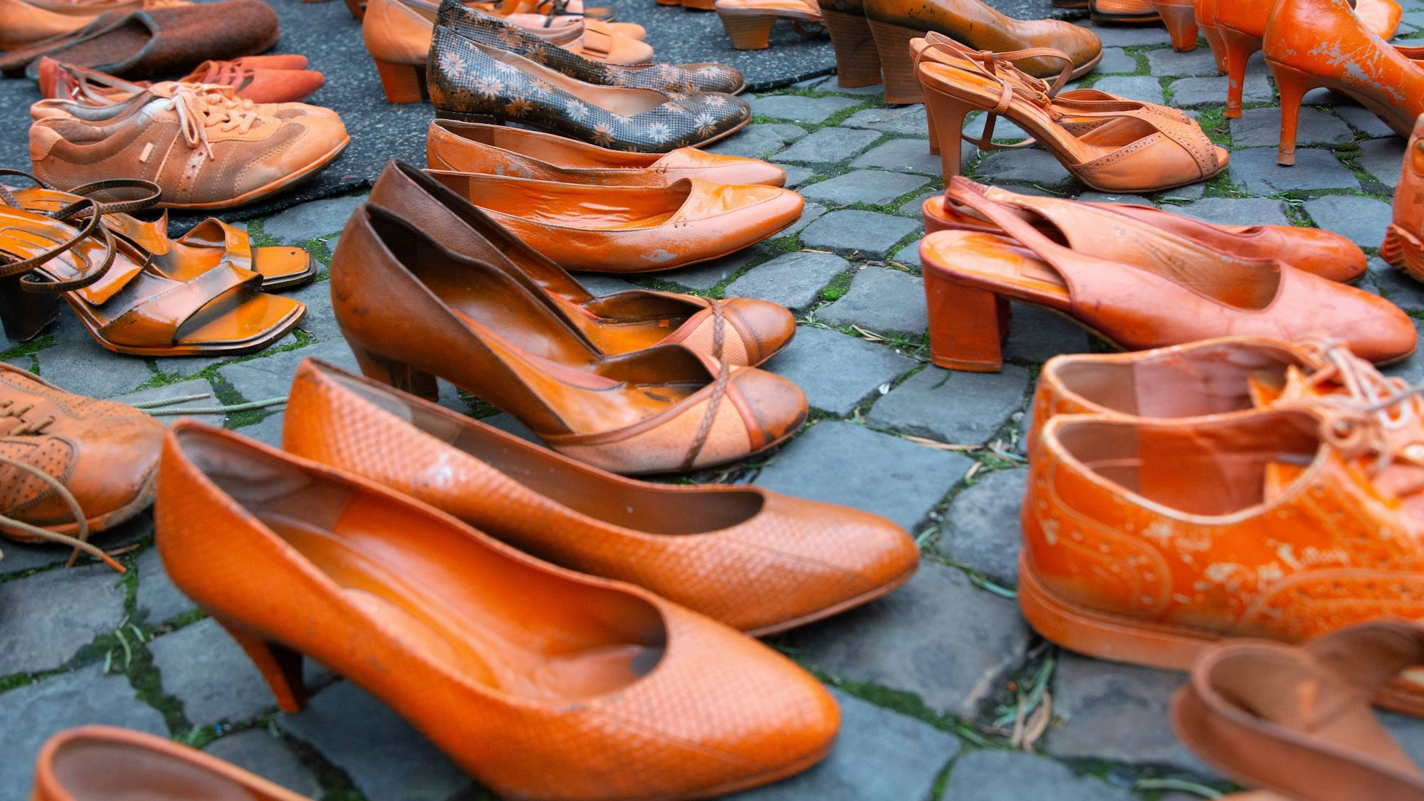 Orangefarbene Frauenschuhe symbolisieren Gewalt gegen Frauen und Mädchen - hier ausgestellt in Köln.