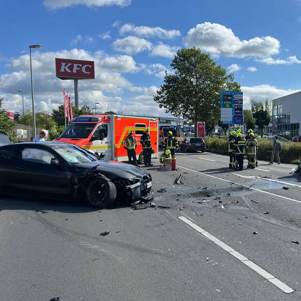 Mehrere beschädigte Autos, ein Rettungswagen und Einsatzkräfte stehen auf ener Fahrbahn