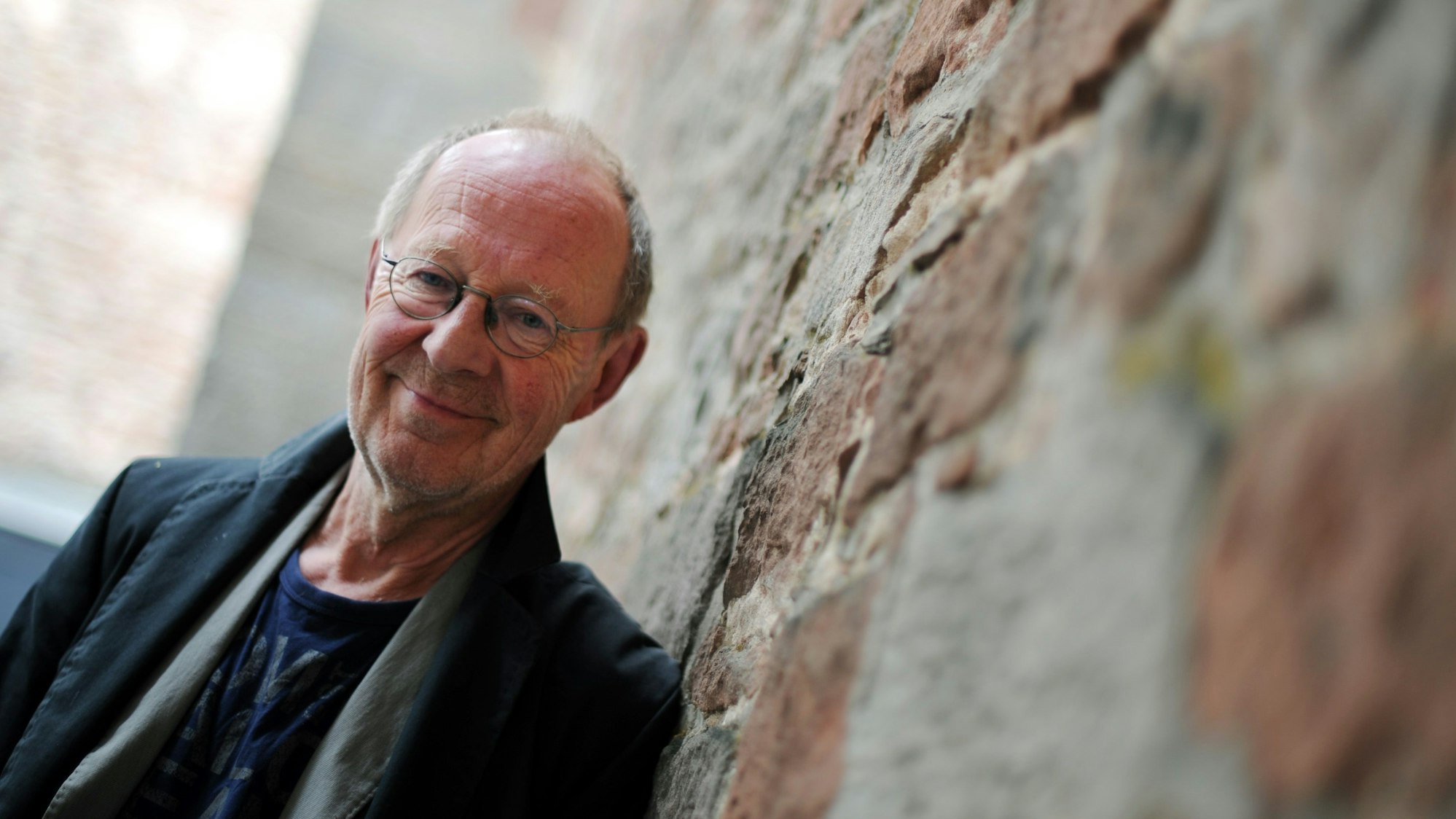 Der Schauspieler Hans Peter Korff lehnt am 2011 an der Wand der Stiftsruine in Bad Hersfeld.