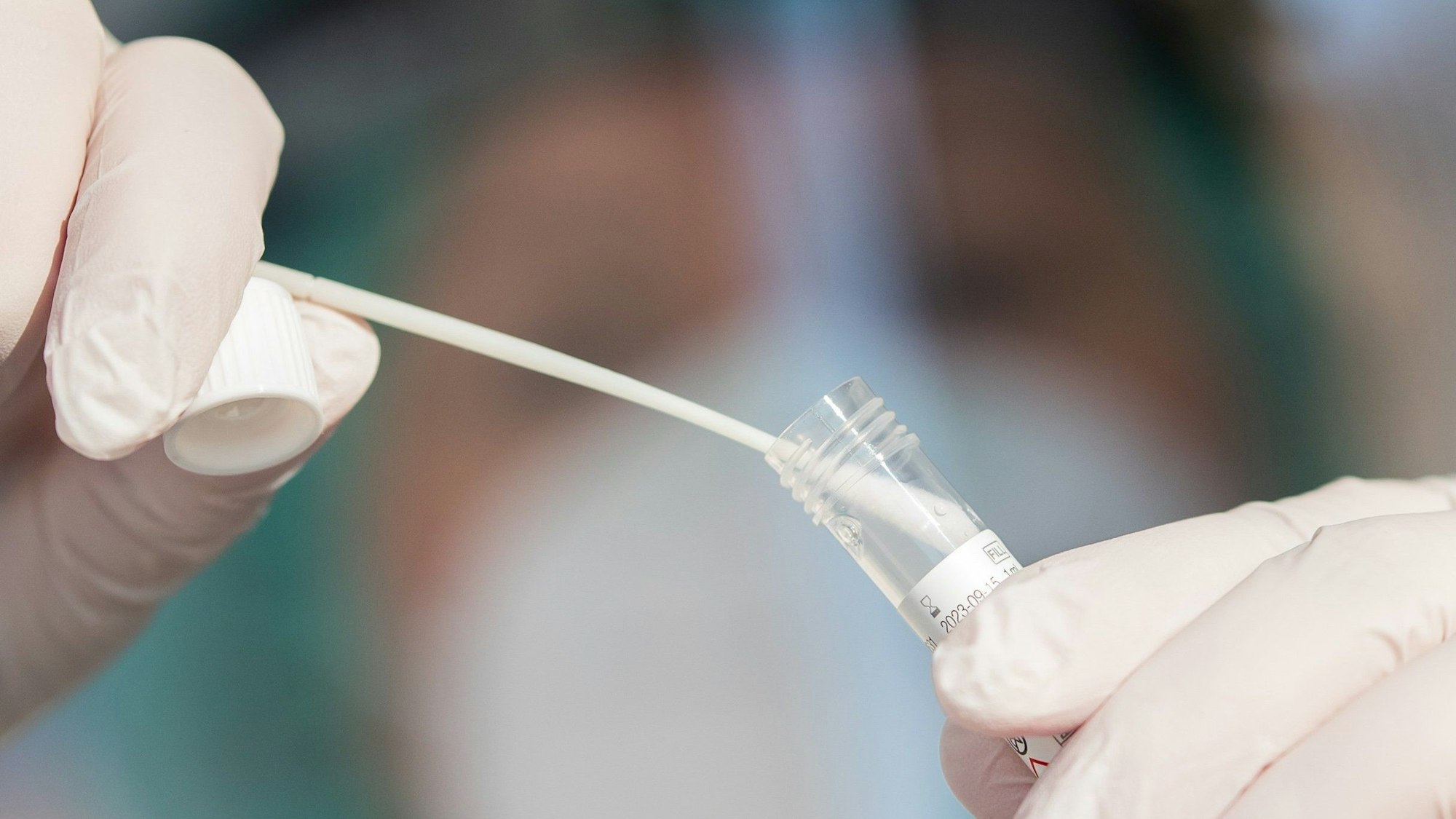 Ein Mitarbeiter eines Corona-Testzentrums zeigt einen Abstrich.