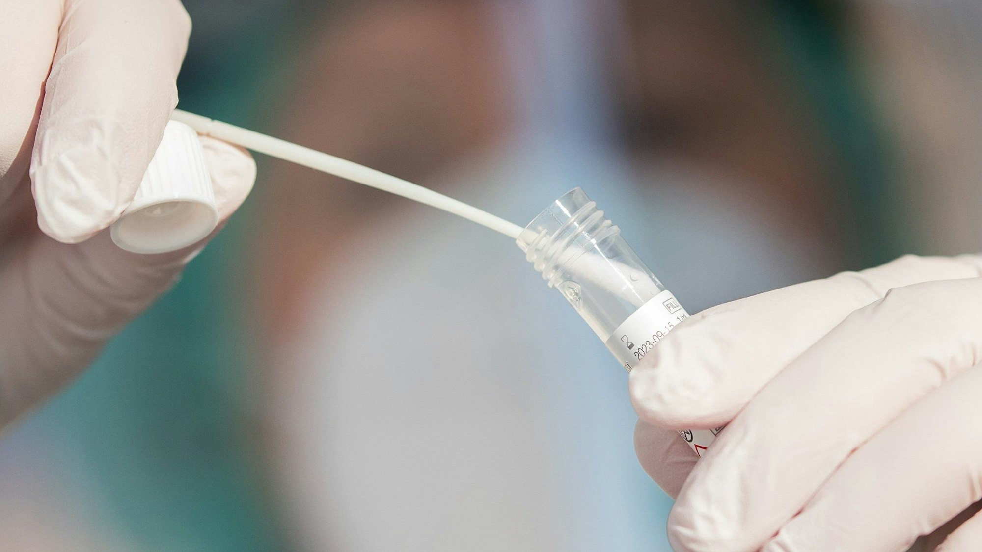 ARCHIV - 25.11.2020, Baden-Württemberg, Nürtingen: ILLUSTRATION - Ein Mitarbeiter eines Corona-Testzentrums zeigt einen Abstrich. Die Schäden wegen Abrechnungsbetrugs im Zusammenhang mit angeblichen Corona-Testzentren liegen in Baden-Württemberg bei mindestens 76 Millionen Euro. (zu dpa: «Mehr als 700 Steuerbetrugsfälle in Corona-Testzentren in NRW») Foto: Tom Weller/dpa +++ dpa-Bildfunk +++