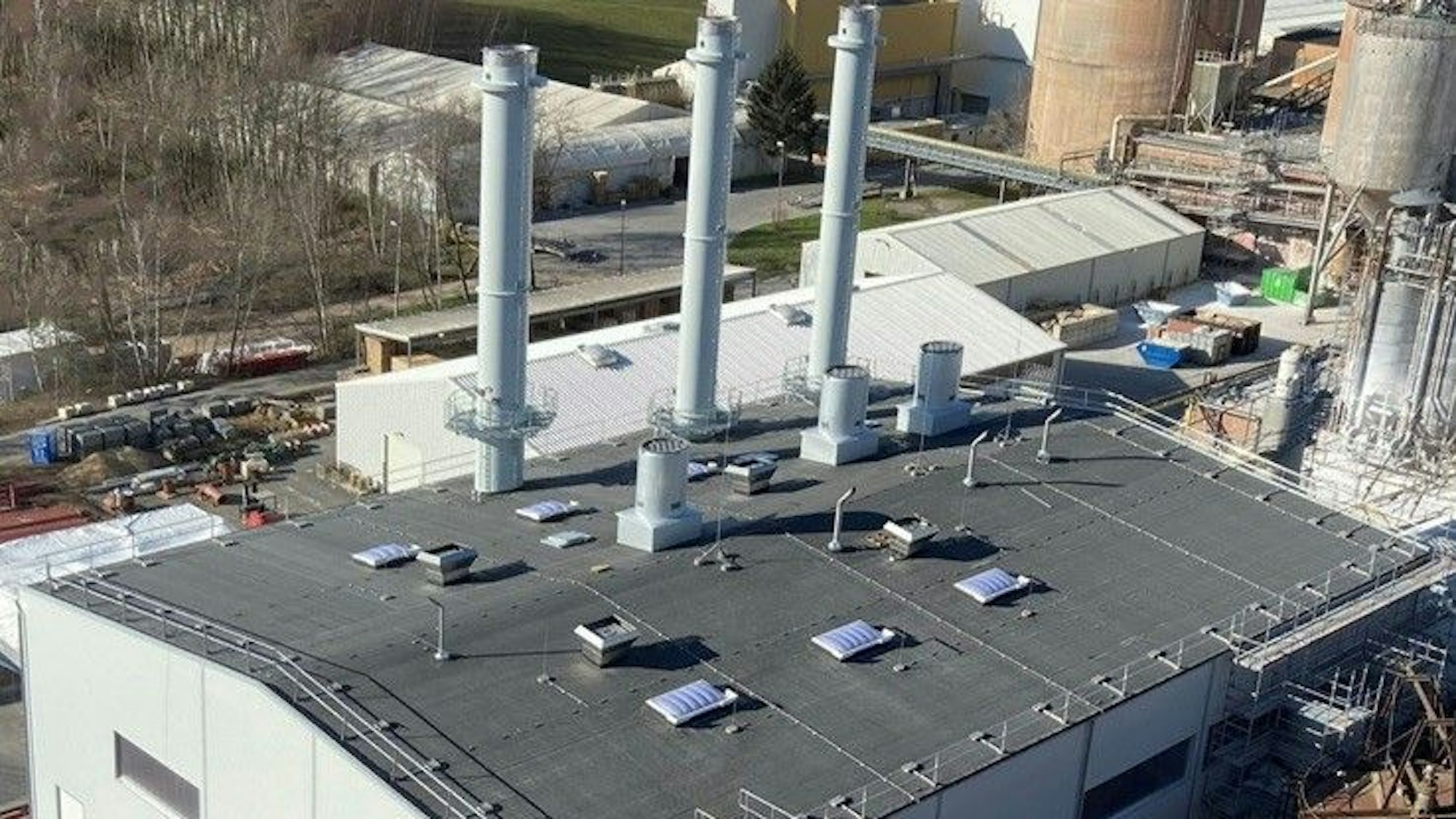 Zu sehen ist das Gebäude des Kraftwerks mit drei Türmen, dahinter das alte Kohlekraftwerk.