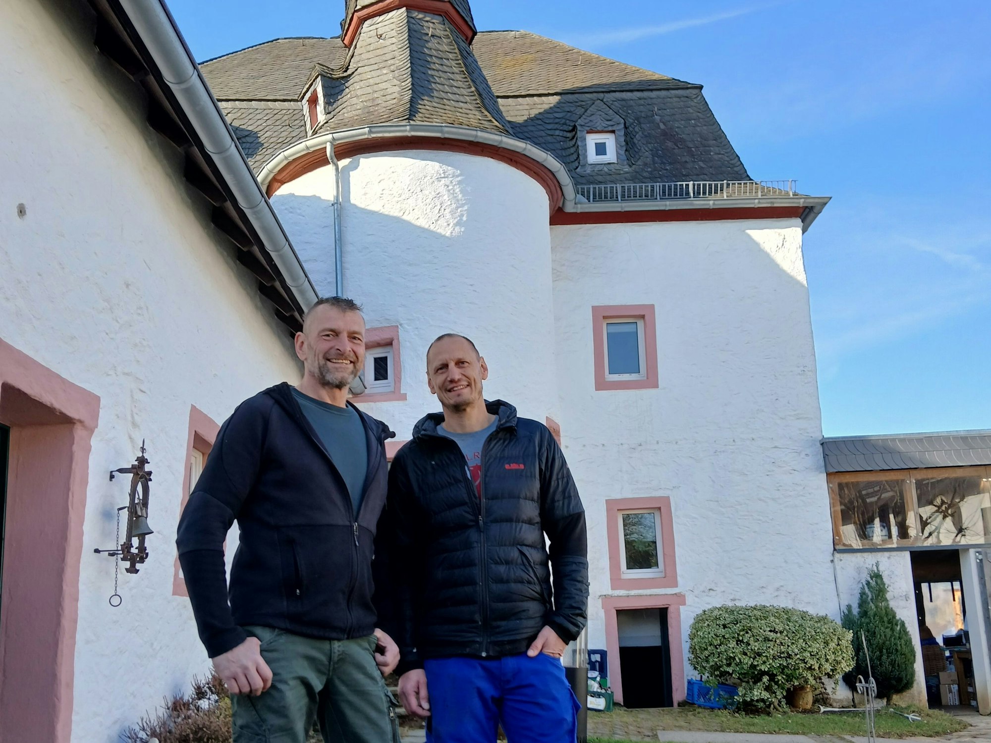 Thomas Claßen und Bernd Thrum (49) stehen im Garten der Burg Marmagen, in der sie leben.