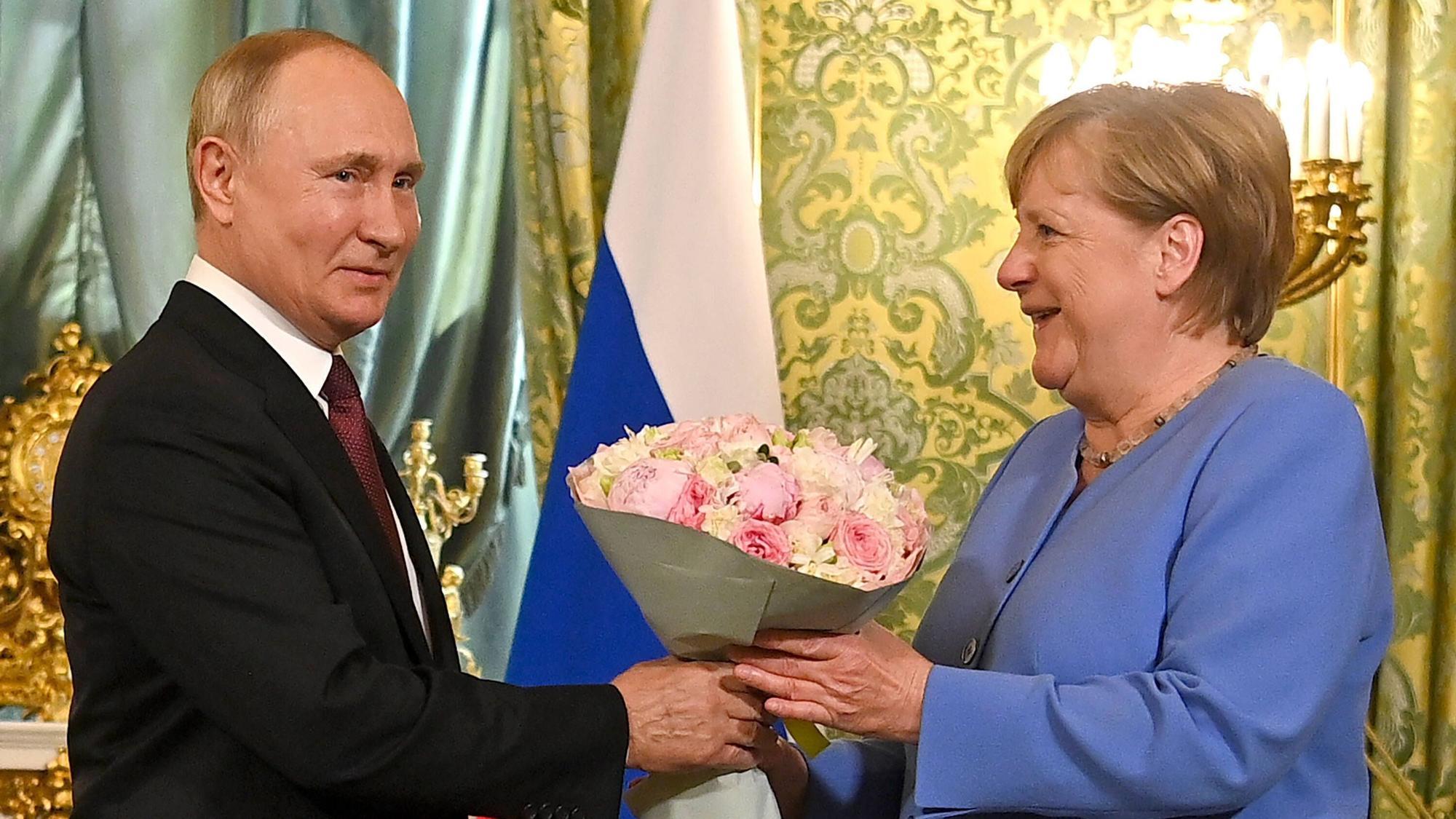 Angela Merkel erhält bei einem Treffen aus dem 2021 einen Blumenstrauß von Wladimir Putin.