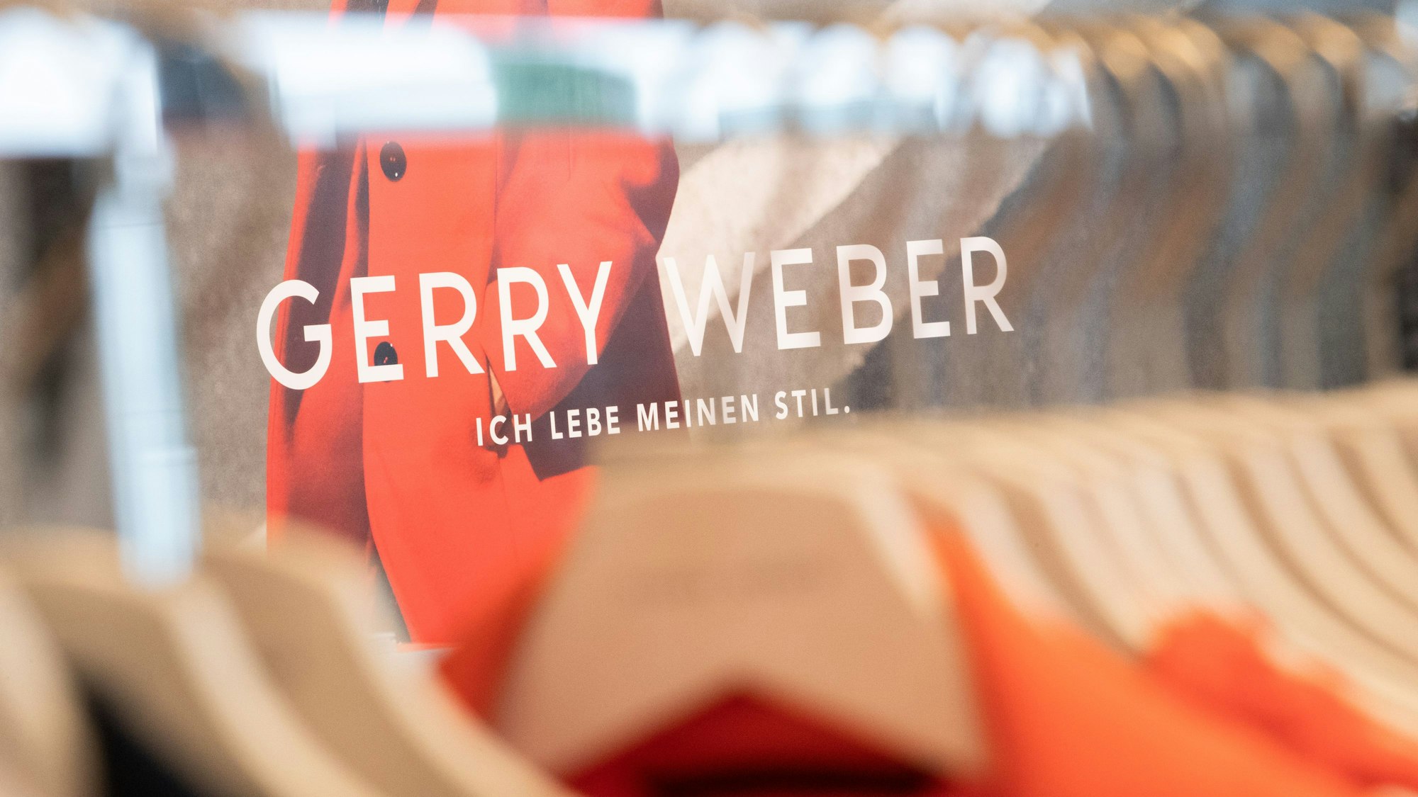 Kleidung des deutschen Modeunternehmens Gerry Weber hängt auf Bügeln an einem Kleiderständer.
