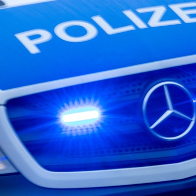 Ein Einsatzfahrzeug der Polizei fährt mit Blaulicht durch eine Stadt.