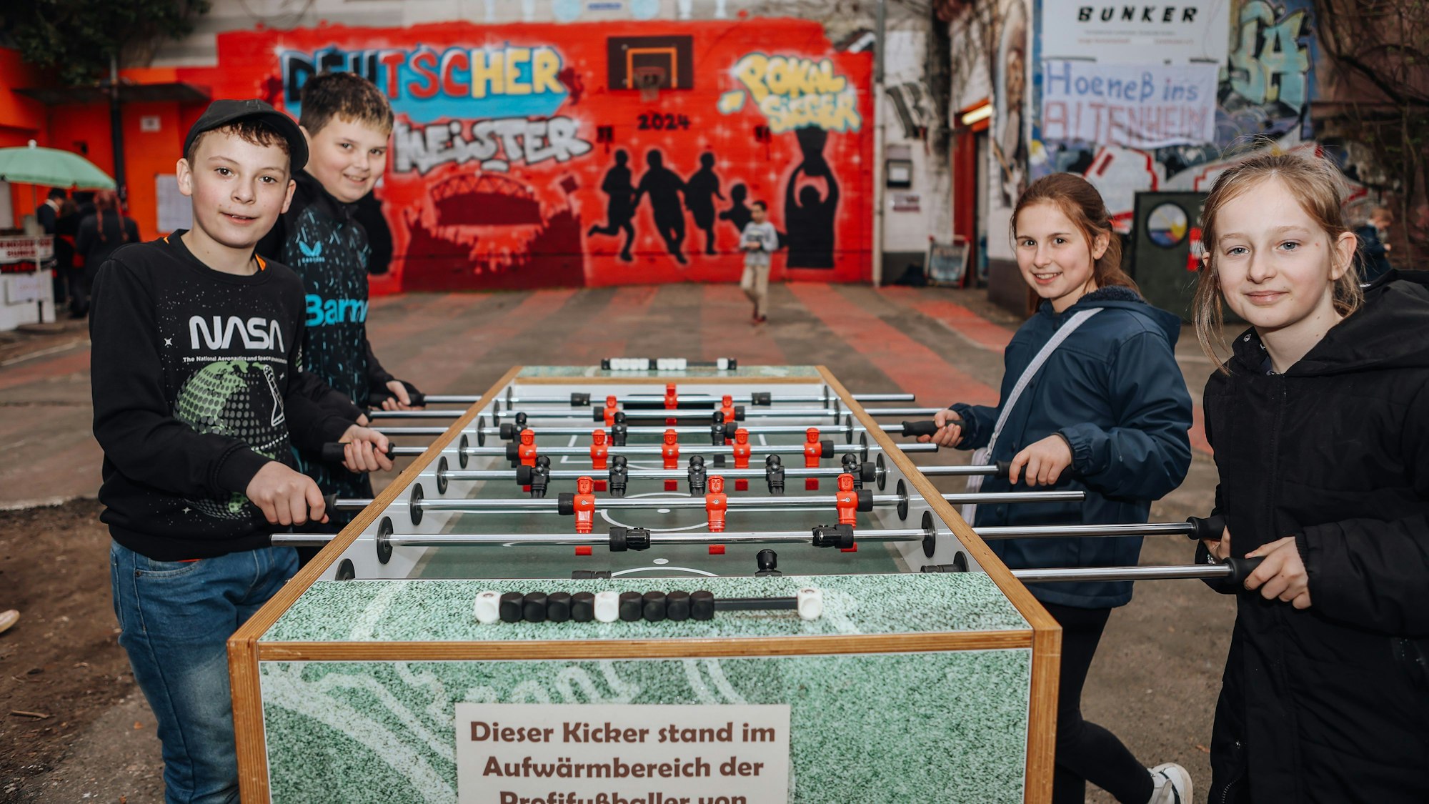 Niklas, Yadon, Alex und Lilli haben zusammen viel Spaß am Kicker.