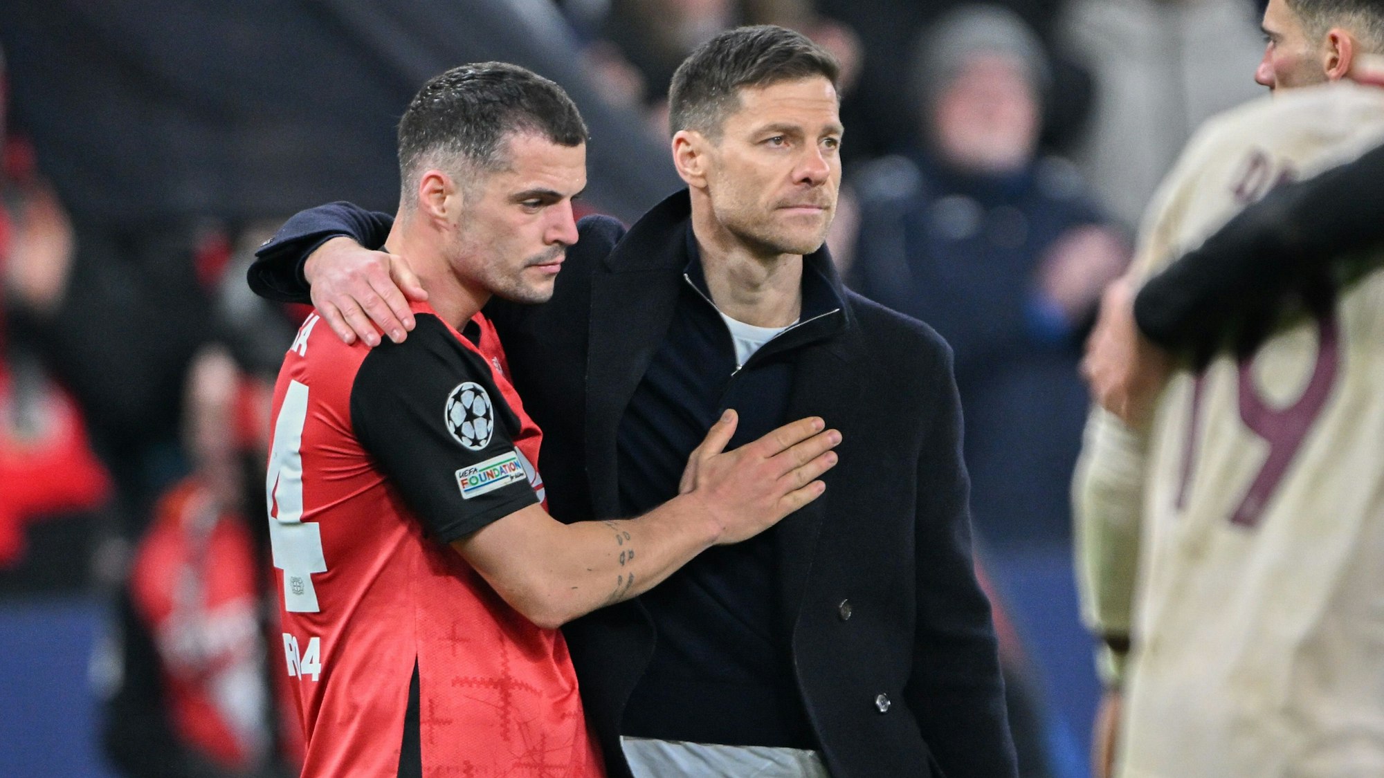 11.03.2025, Nordrhein-Westfalen, Leverkusen: Fußball: Champions League, Bayer Leverkusen - Bayern München, K.o.-Runde, Achtelfinale, Rückspiele, BayArena. Bayers Granit Xhaka (l) steht nach der Niederlage mit Bayers Trainer Xabi Alonso zusammen. Foto: Federico Gambarini/dpa +++ dpa-Bildfunk +++