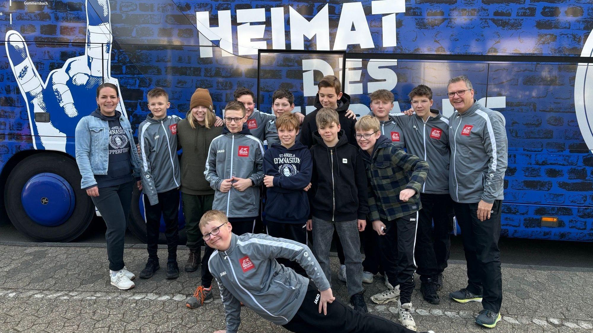 Mannschaftsfoto vor dem Bus mit dem Schriftzug "Heimat des Handballs"