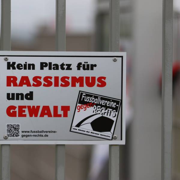 Das Symbolbild zeigt eine Plakette mit der Aufschrift „Kein Platz für Rassismus und Gewalt“.