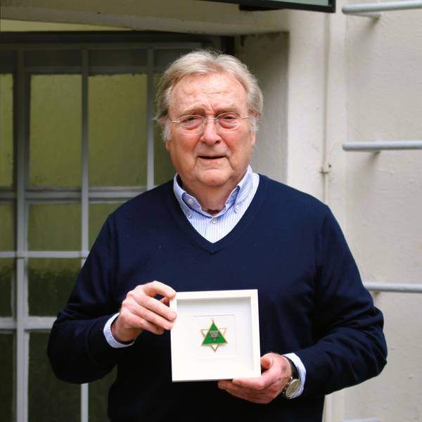 Gerhard Küpper präsentiert den eingerahmten grün-weißen, sternförmigen Karnevalsorden seines Vaters Karl Küpper.