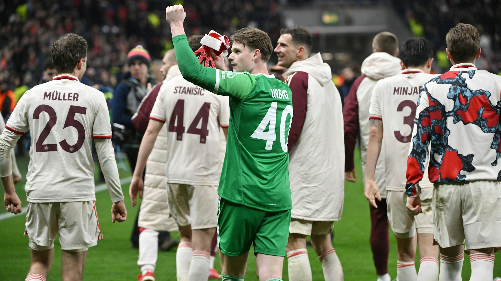Jonas Urbig feiert mit den Spielern von Bayern München den Einzug ins Viertelfinale der Champions League.