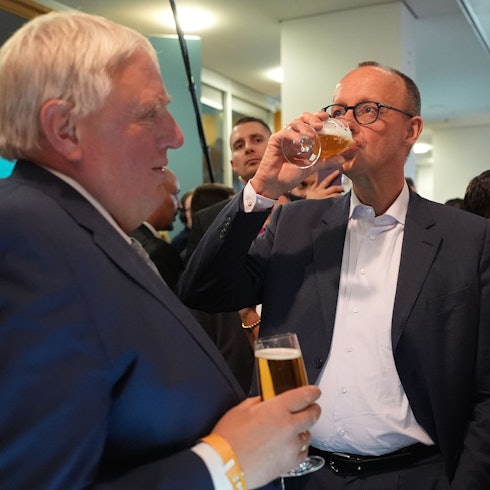 23.02.2025, Berlin: Friedrich Merz (CDU), Parteivorsitzender und Kanzlerkandidat, trinkt neben Karl-Josef Laumann (CDU), Minister für Arbeit, Gesundheit und Soziales des Landes Nordrhein-Westfalen, im Konrad-Adenauer-Haus ein Bier. Am Sonntag fand die vorgezogene Wahl zum 21. Deutschen Bundestag statt. Foto: Marcus Brandt/dpa +++ dpa-Bildfunk +++