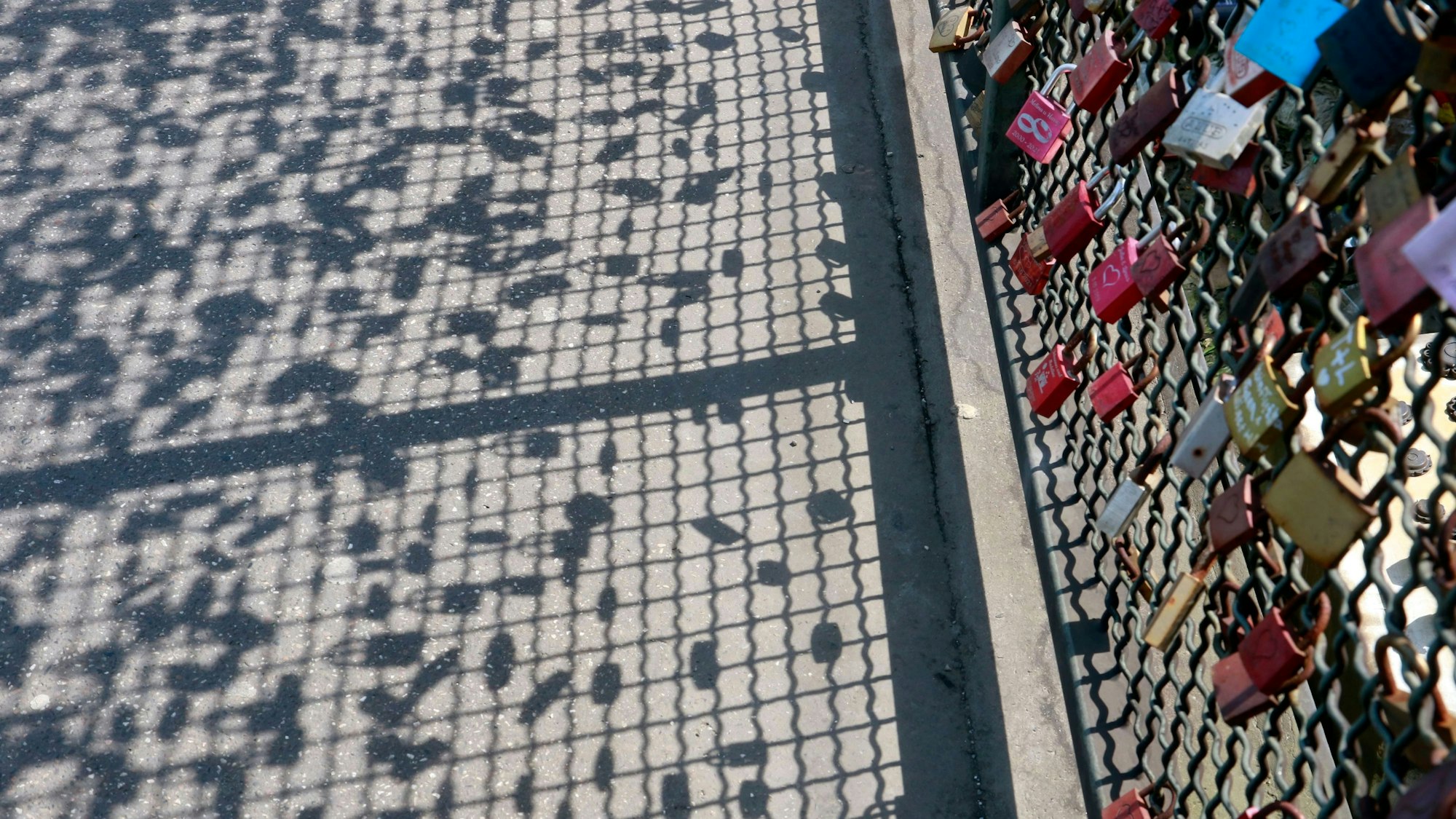 Der Schatten der Liebesschlösser auf dem Boden der Hohenzollernbrücke.