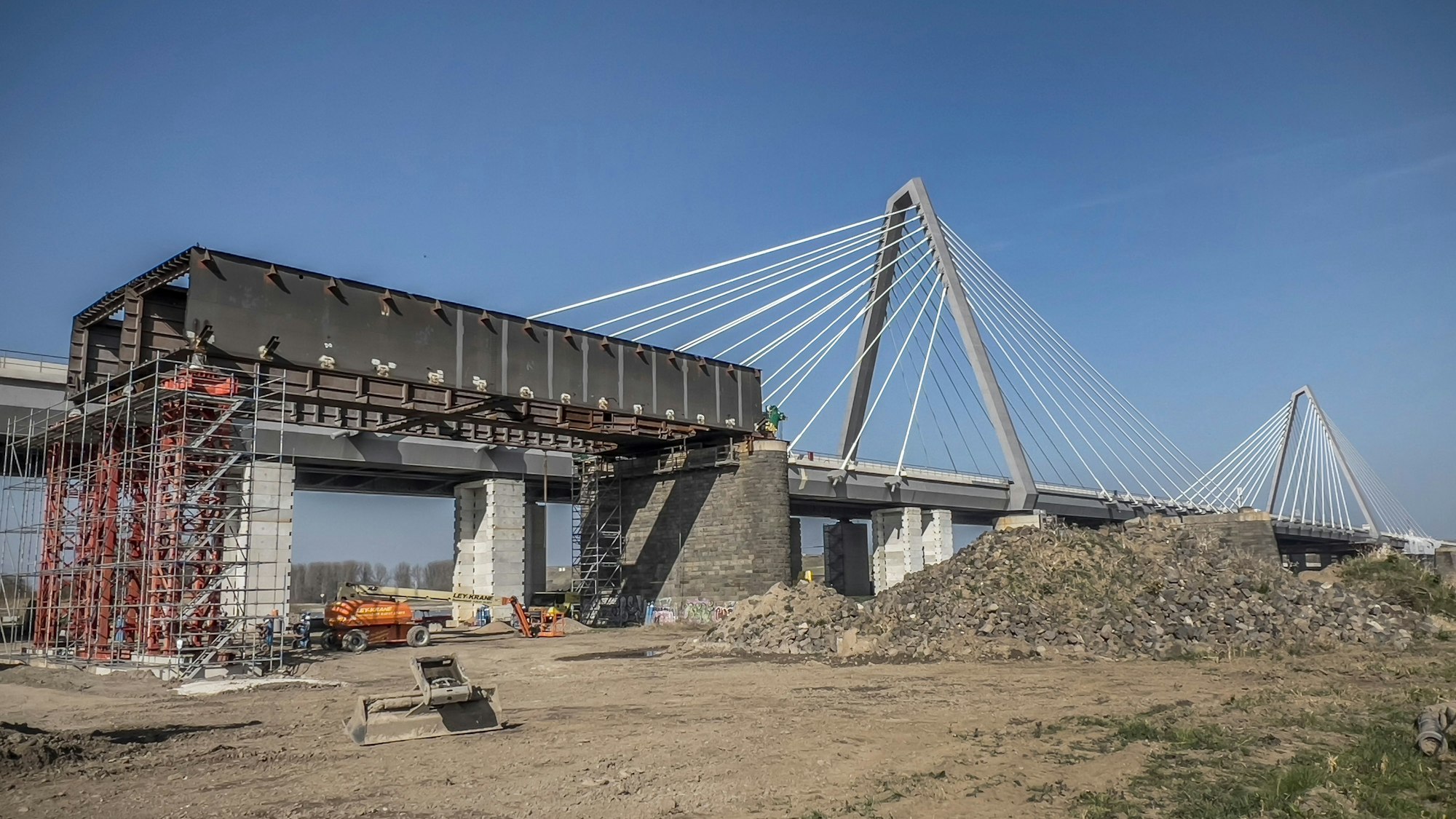 Der letzte Rest vom alten Stahl-Hohlkasten der alten Leverkusener Rheinbrücke ist Anfang dieser Woche auf der Merkenicher Seite von den Pfeilern heruntergehoben worden und wird jetzt mit Schneidbrennern zerkleinert.