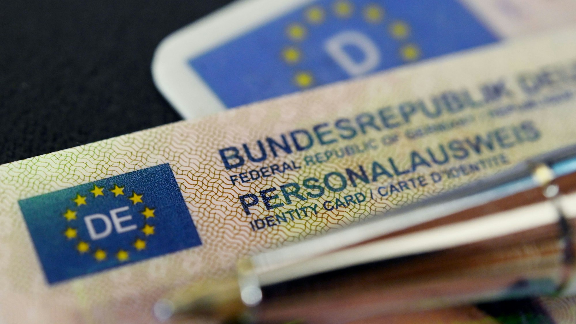 Ein Personalausweis der Bundesrepublik Deutschland liegt auf einem Führerschein.