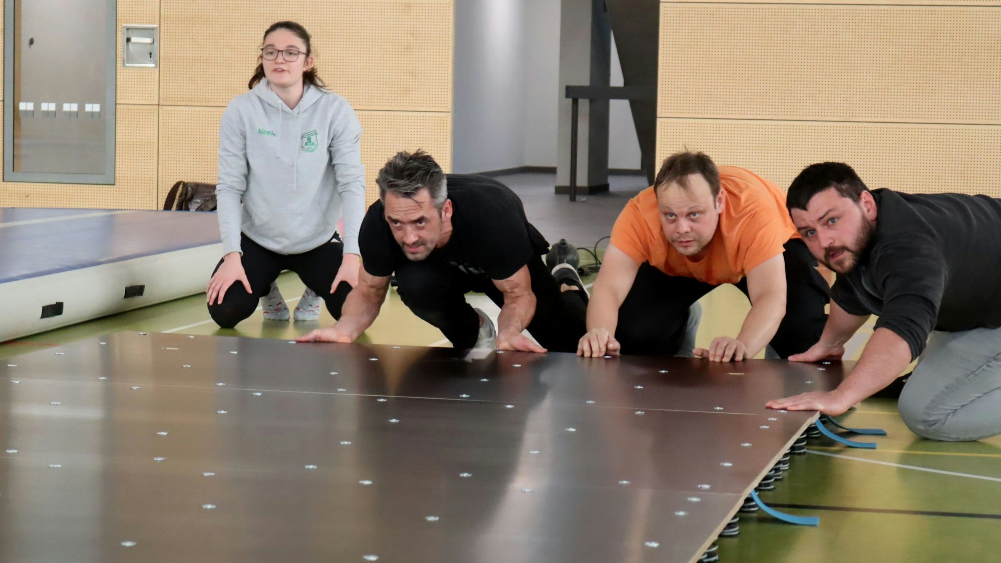 Drei Männer schieben die Bestandteile der Akrobahn zusammen.