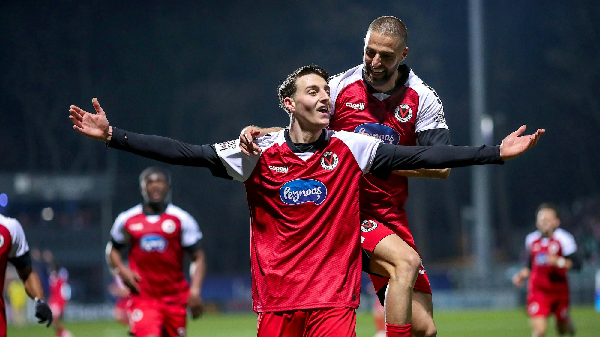 Zwei Fußballspieler jubeln gemeinsam über ein Tor.