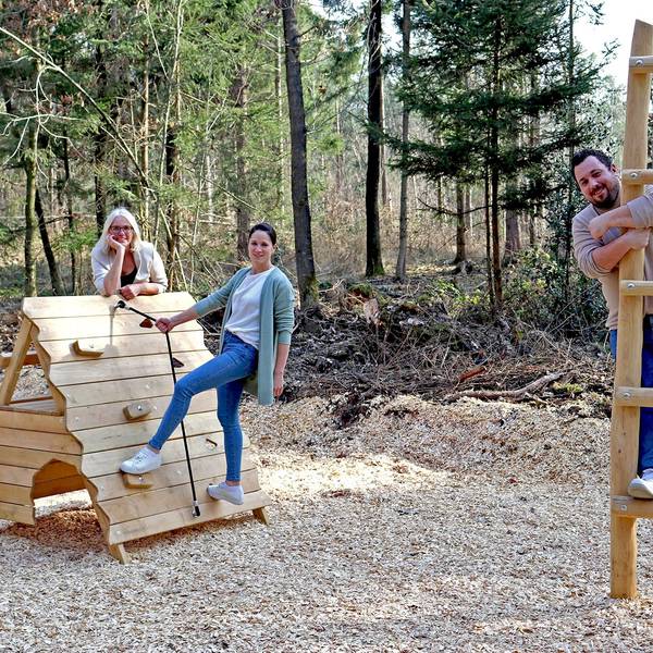 Zwei Frauen und ein Mann auf Klettergeräten im Wald