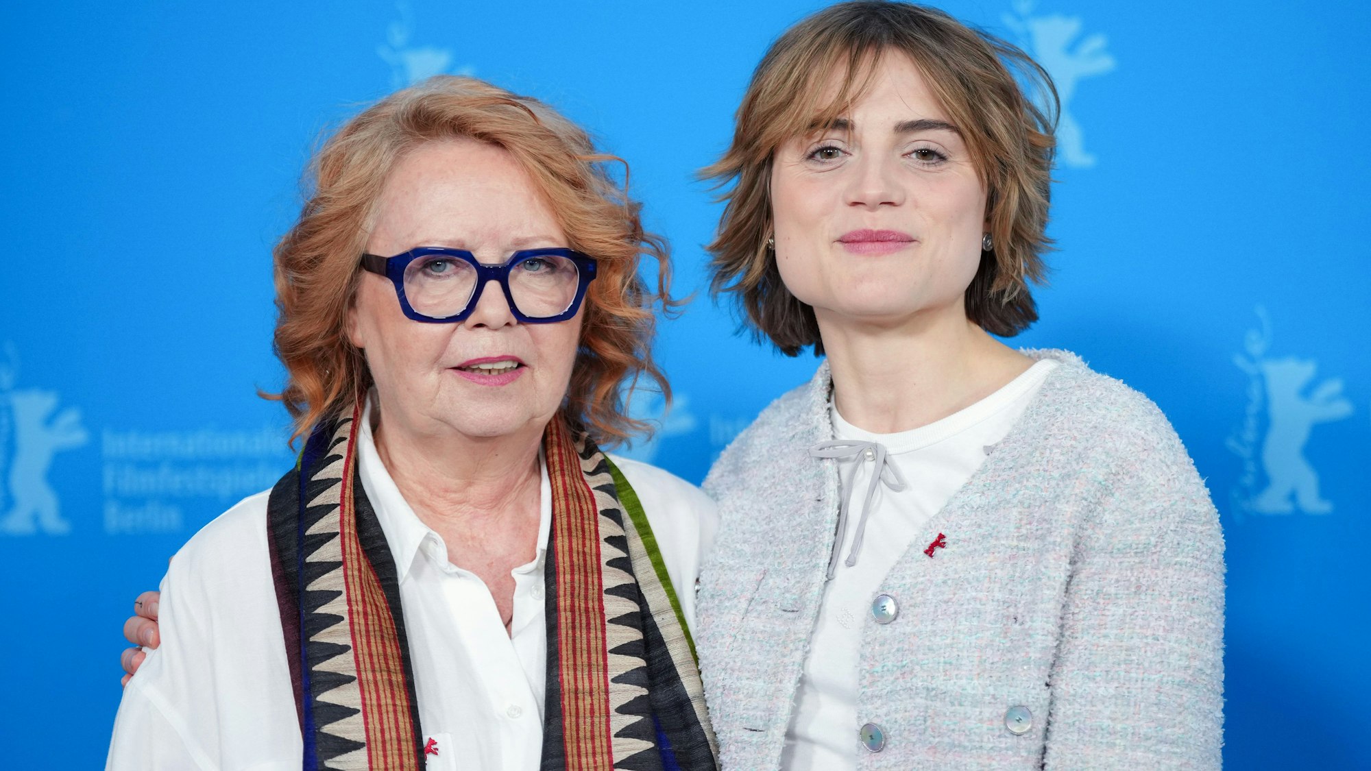 15.02.2025, Berlin: Die Schauspielerin Mala Emde (r) und Musikproduzentin Vera Brandes (l) stehen beim Photocall zum Film "Köln 75" vor der blauen Wand.