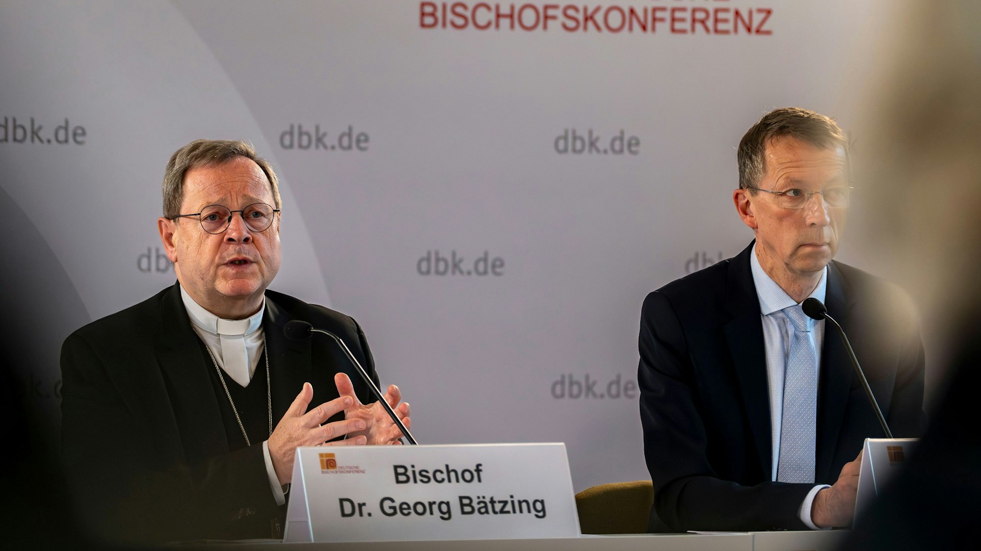 Dr. Georg Bätzing, Vorsitzender der Bischofskonferenz, sitzt an einem Tisch und spricht zum Abschluss der Bischofskonferenz in ein Mikrofon.