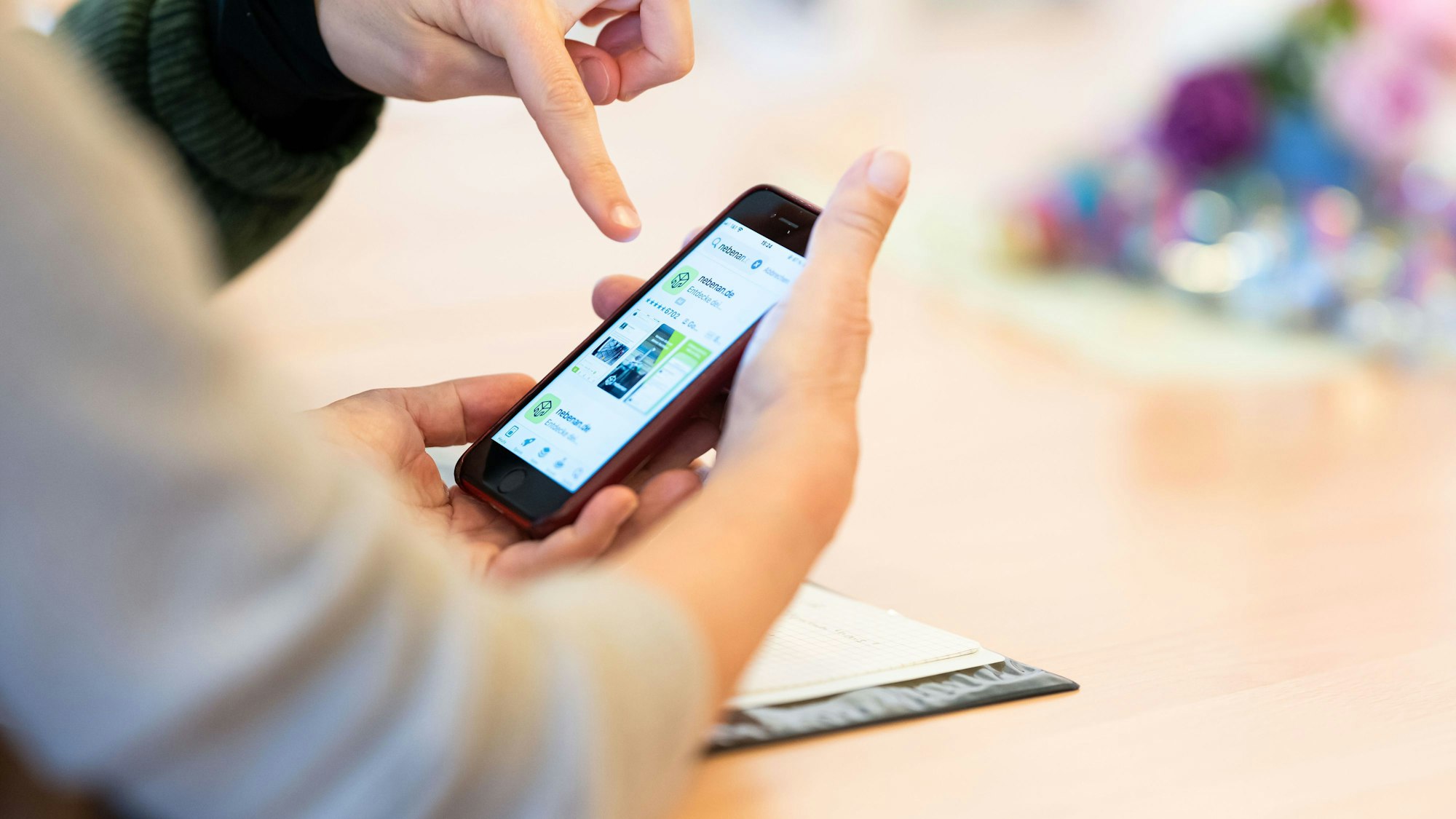 Eine Beraterin beantwortet während der Smartphone-Sprechstunde für Senioren Fragen rund um ein iPhone.