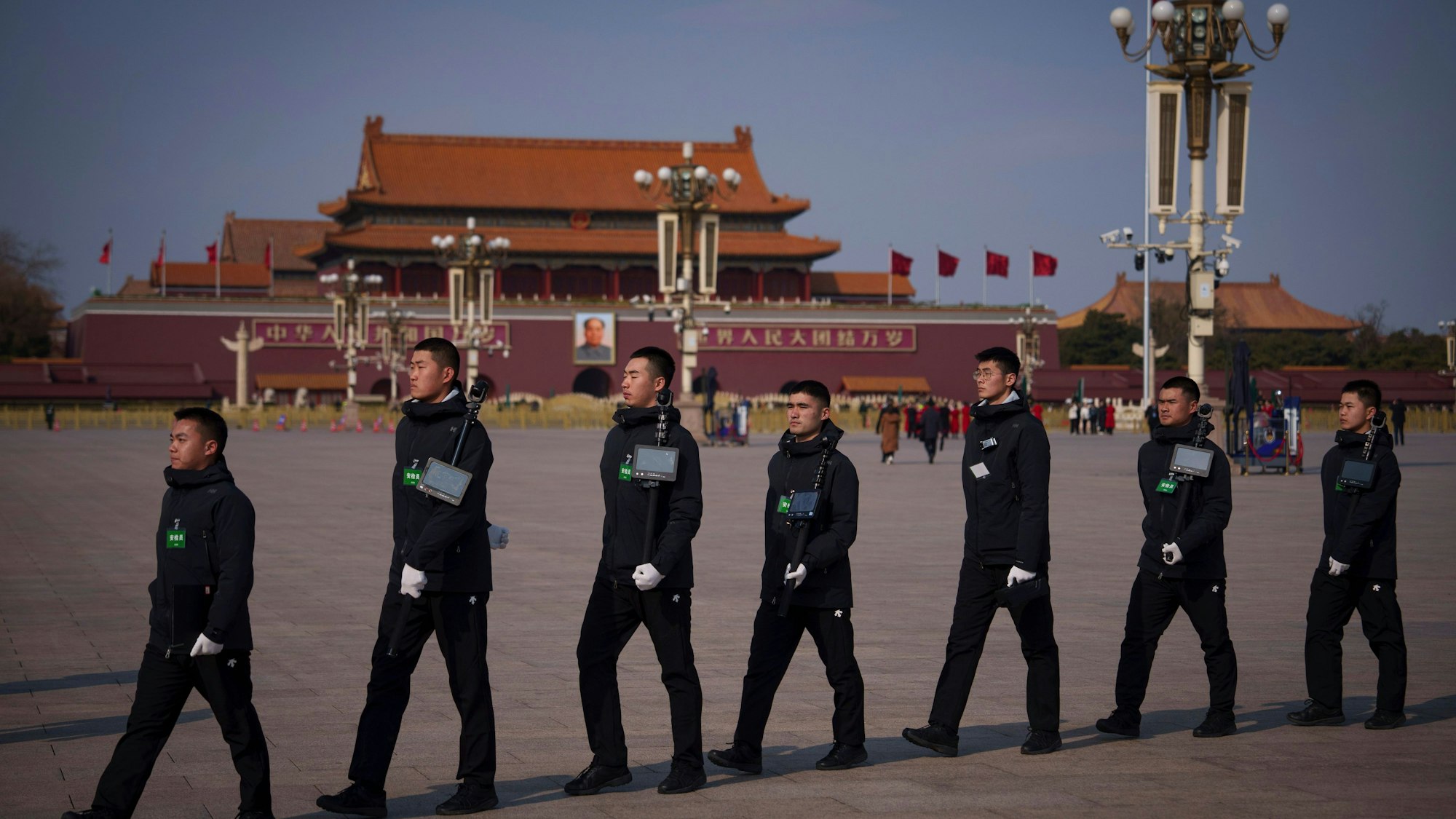 04.03.2025, China, Peking: Polizeistreifen gehen auf dem Platz des Himmlischen Friedens vor der Eröffnungssitzung der Politischen Konsultativkonferenz des Chinesischen Volkes (CPPCC)