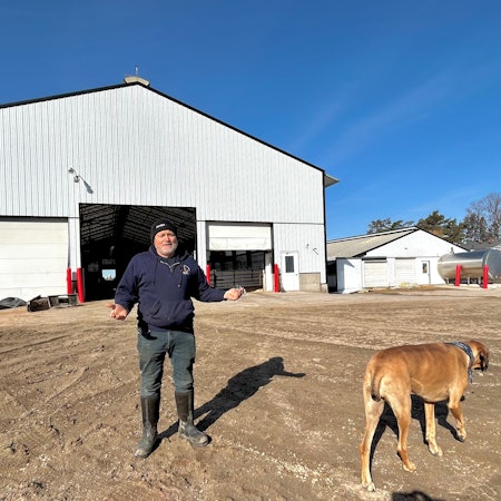Milchfarmer Hans Breitenmoser steht mit seiner Hündin Fern auf seiner Farm in Merrill, Wisconsin.