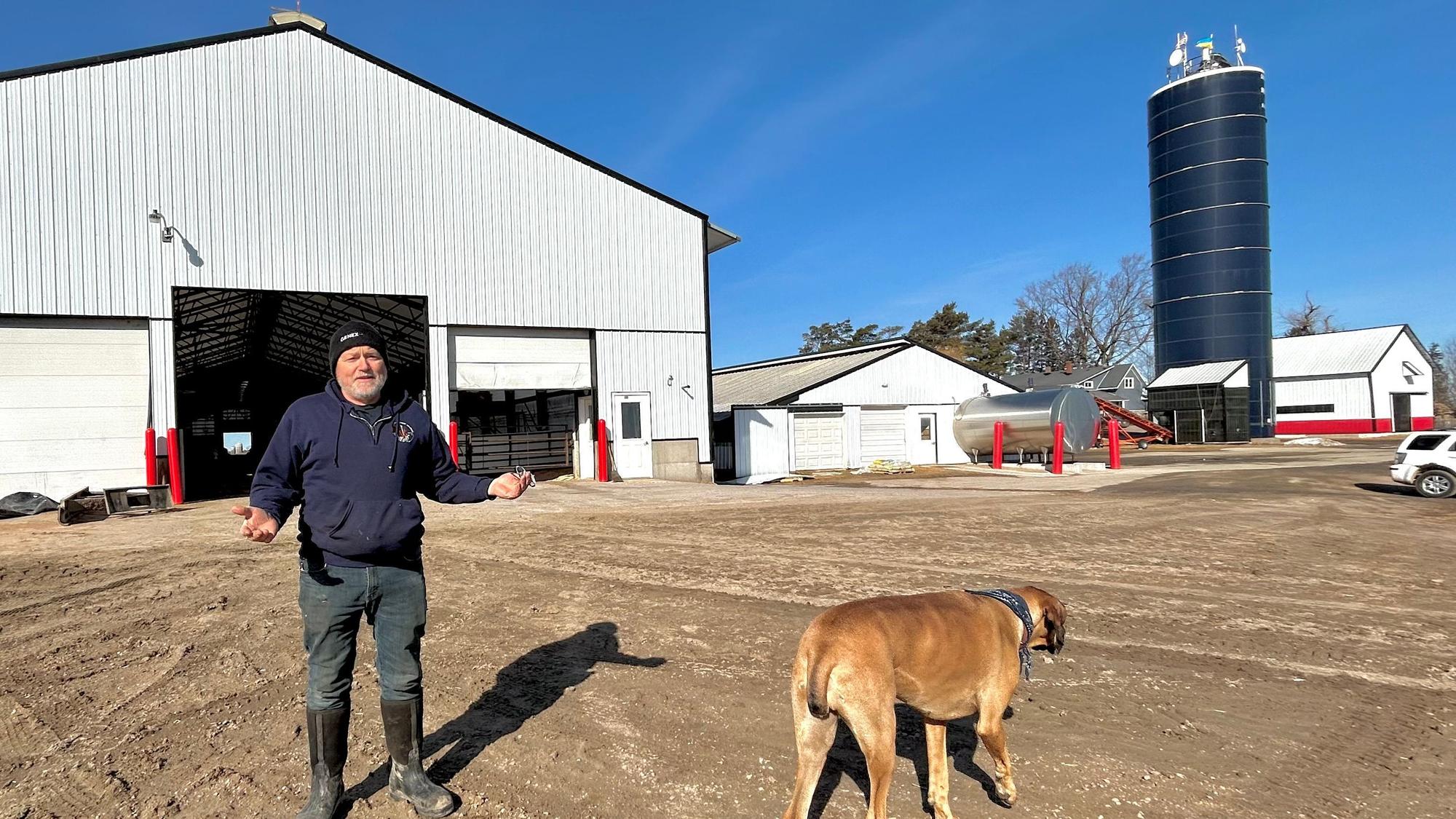 Milchfarmer Hans Breitenmoser steht mit seiner Hündin Fern auf seiner Farm in Merrill, Wisconsin.
