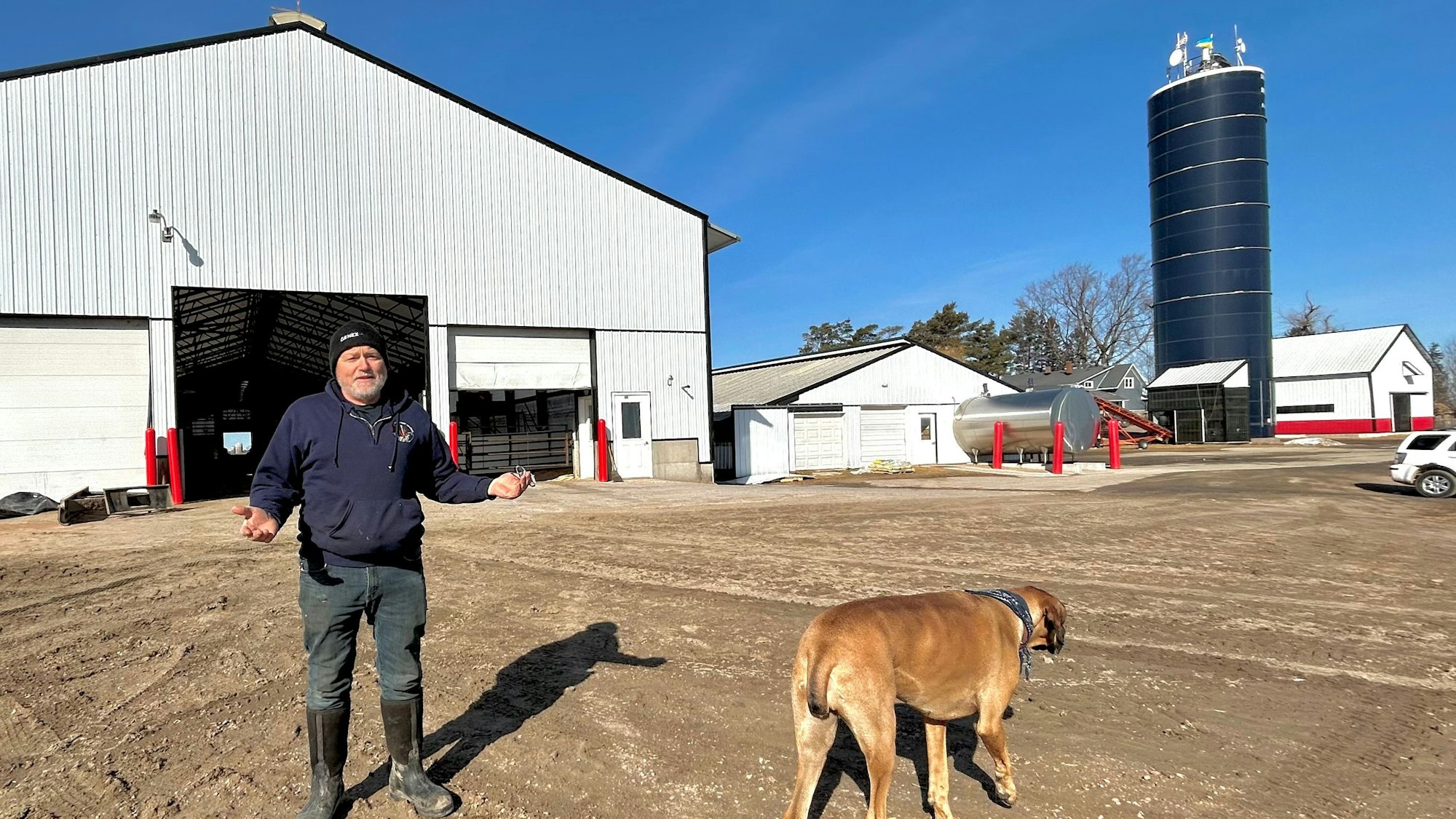 Milchfarmer Hans Breitenmoser steht mit seiner Hündin Fern auf seiner Farm in Merrill, Wisconsin.