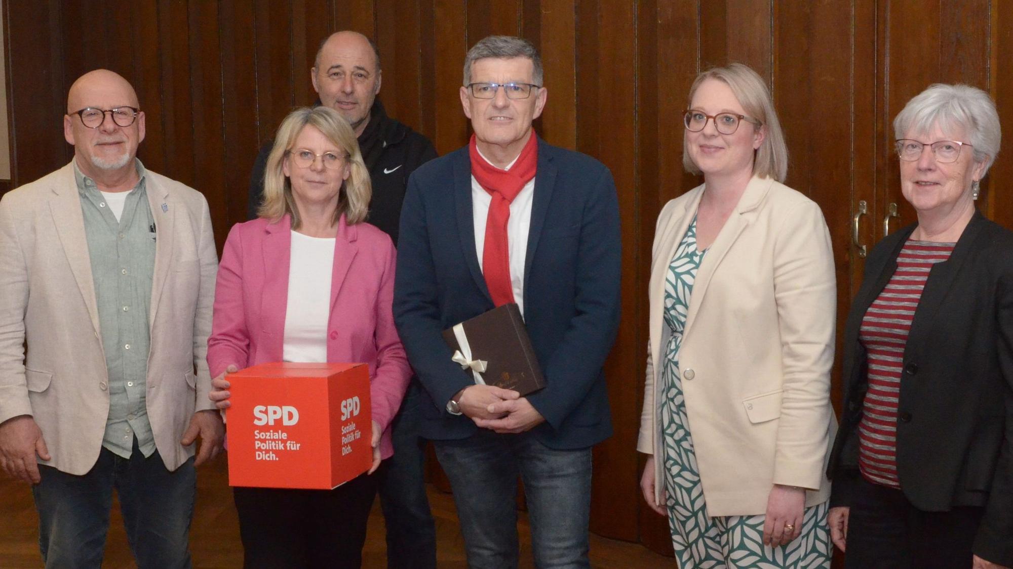 Drei Frauen und drei Männer haben sich zu einem Gruppenbild aufgestellt.