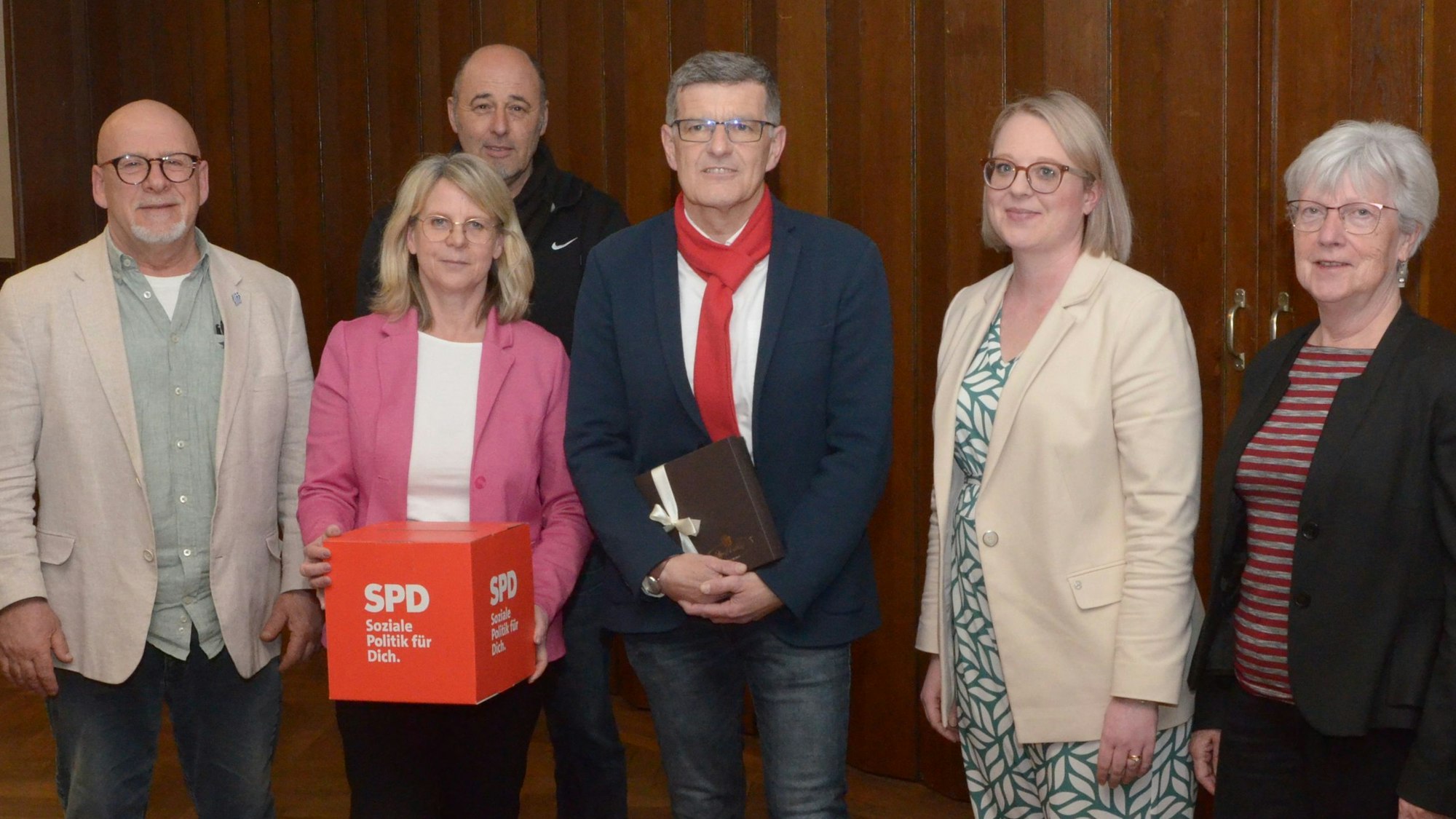 Drei Frauen und drei Männer haben sich zu einem Gruppenbild aufgestellt.